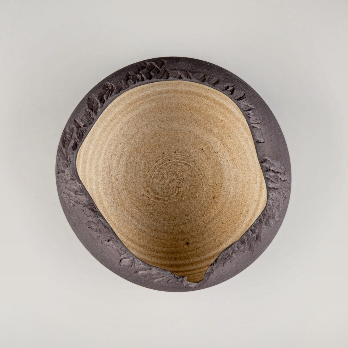 Top view of artisan ceramic bowl showing golden-glazed interior and unglazed matte edges.
