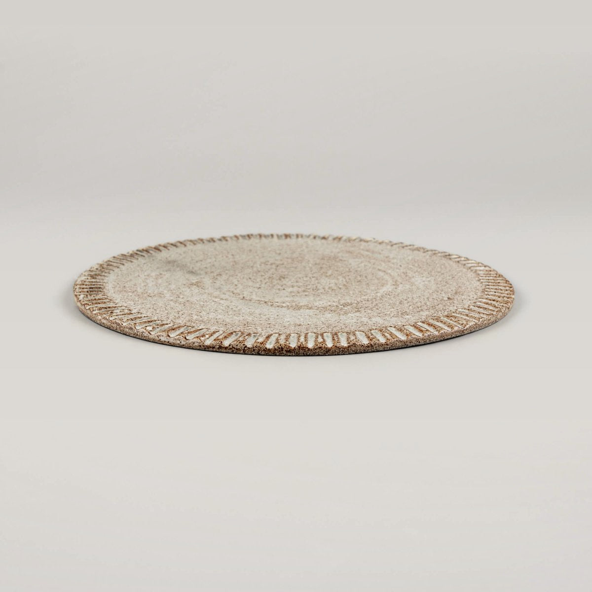 Flat handcrafted ceramic plate ideal for fine dining and culinary presentation.