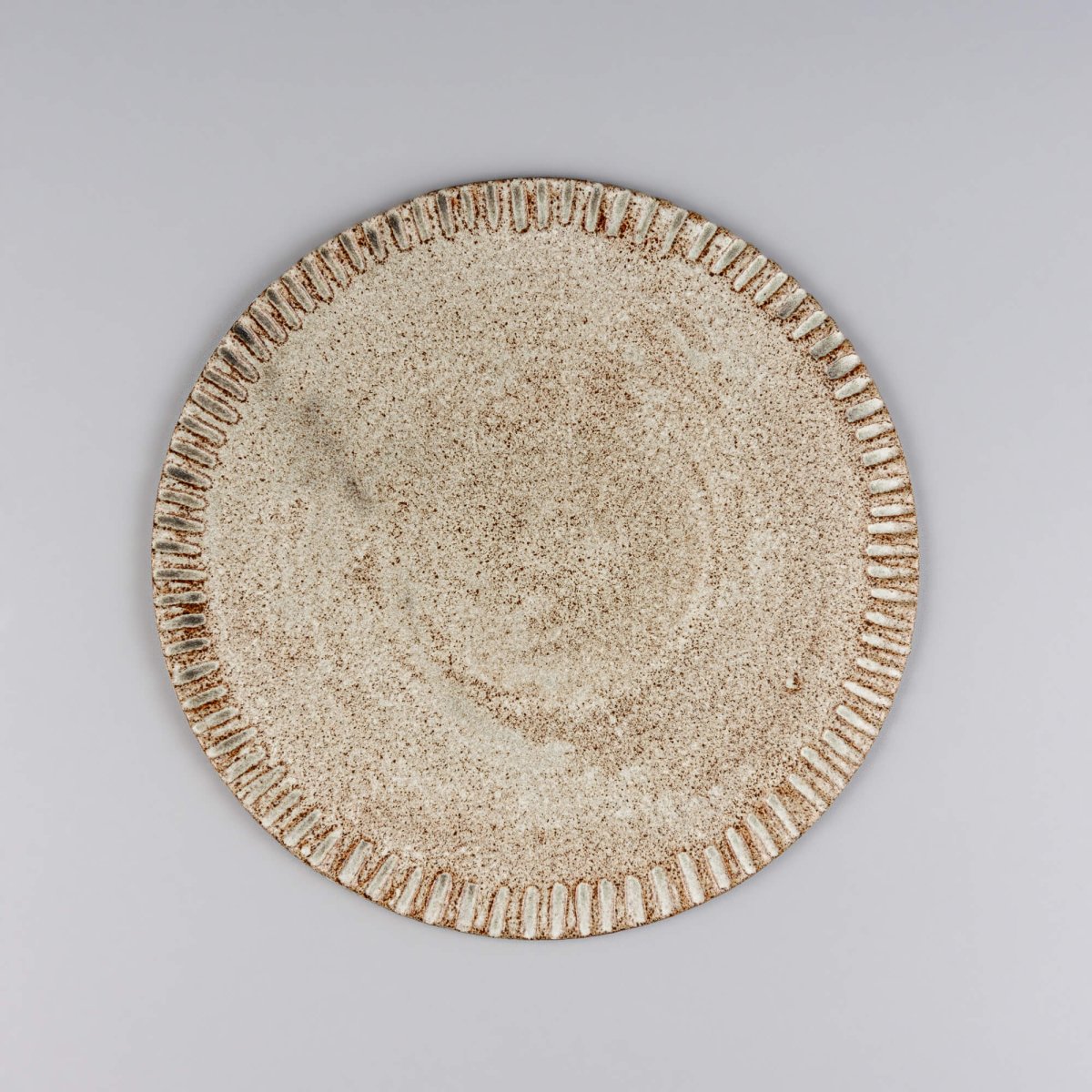 Small unique ceramic dessert plate with hand-carved rim and matte speckled glaze finish.