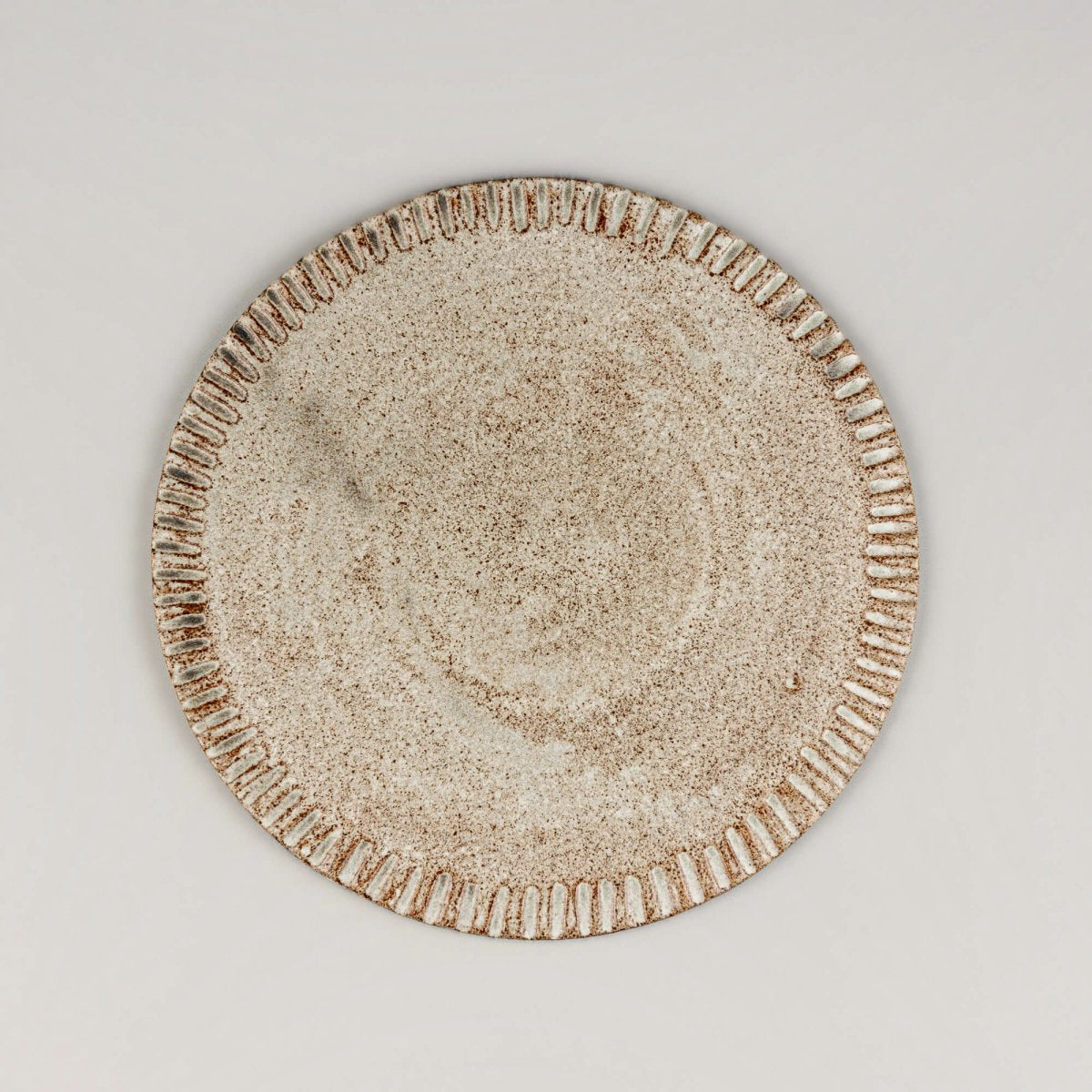 Small unique ceramic dessert plate with hand-carved rim and matte speckled glaze finish.