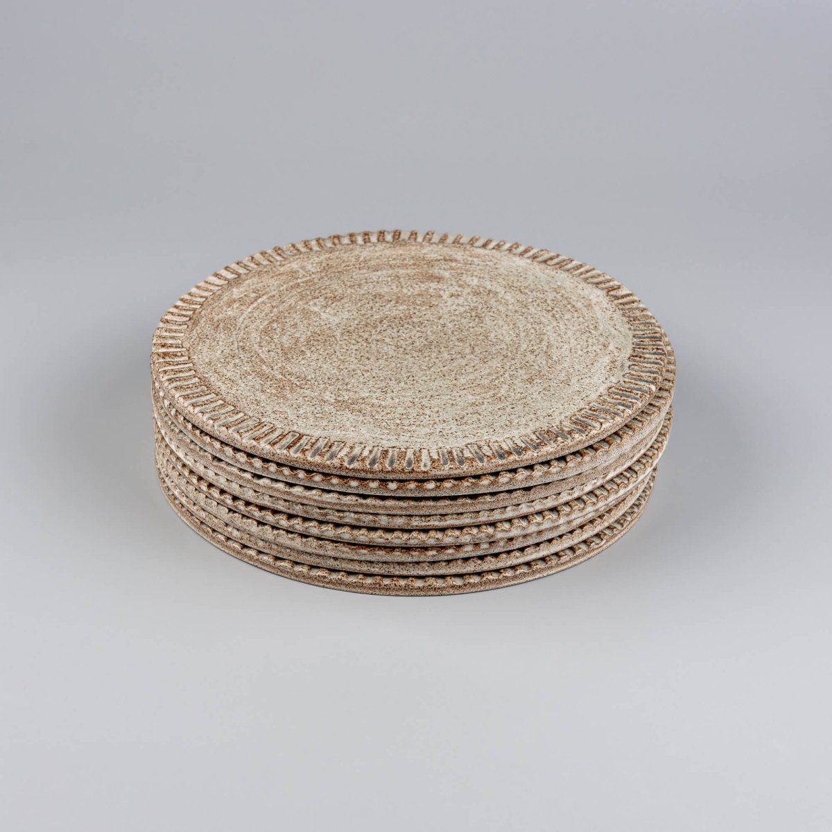 Stacked ceramic plates showcasing fine craftsmanship and earthy glaze.