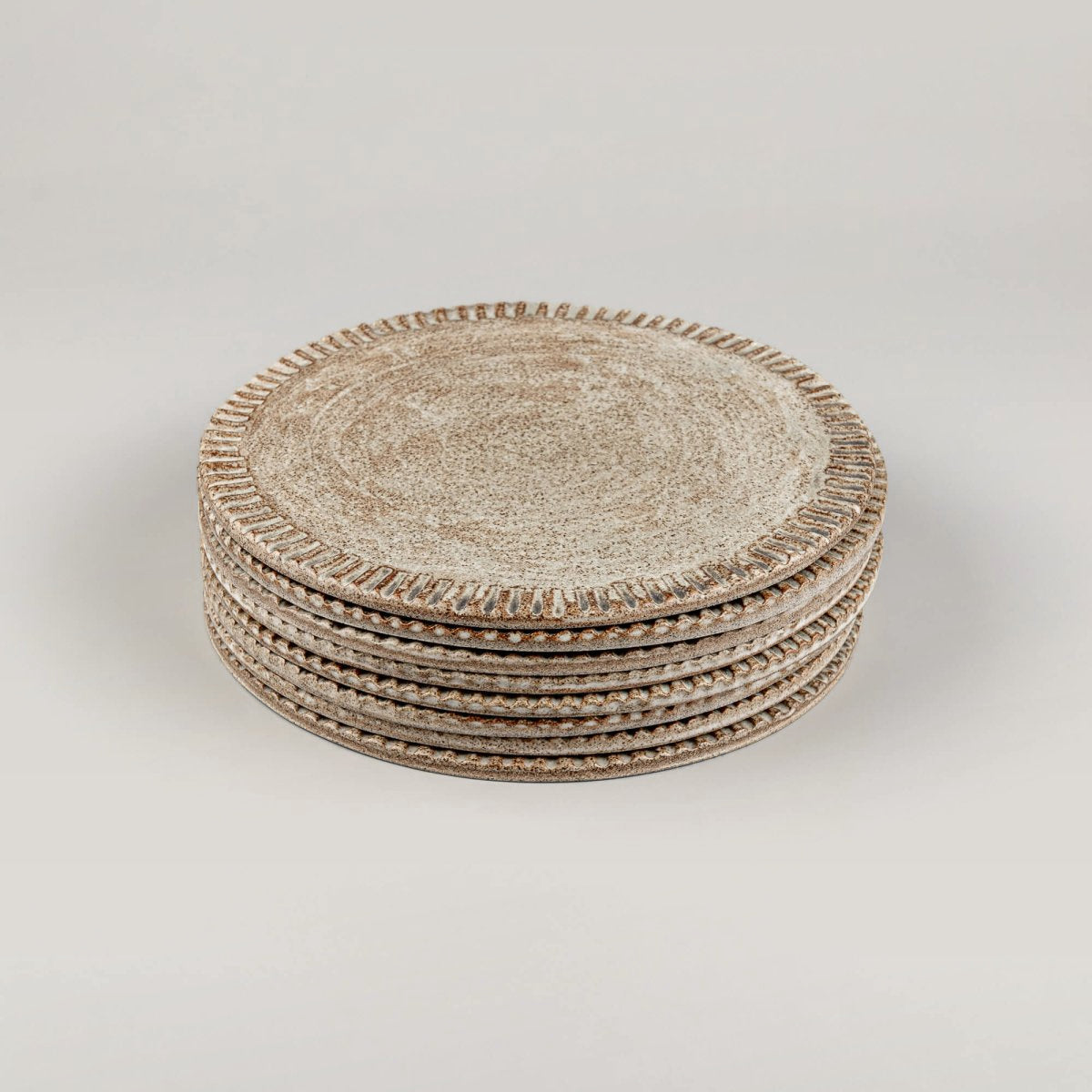 Stacked ceramic plates showcasing fine craftsmanship and earthy glaze.