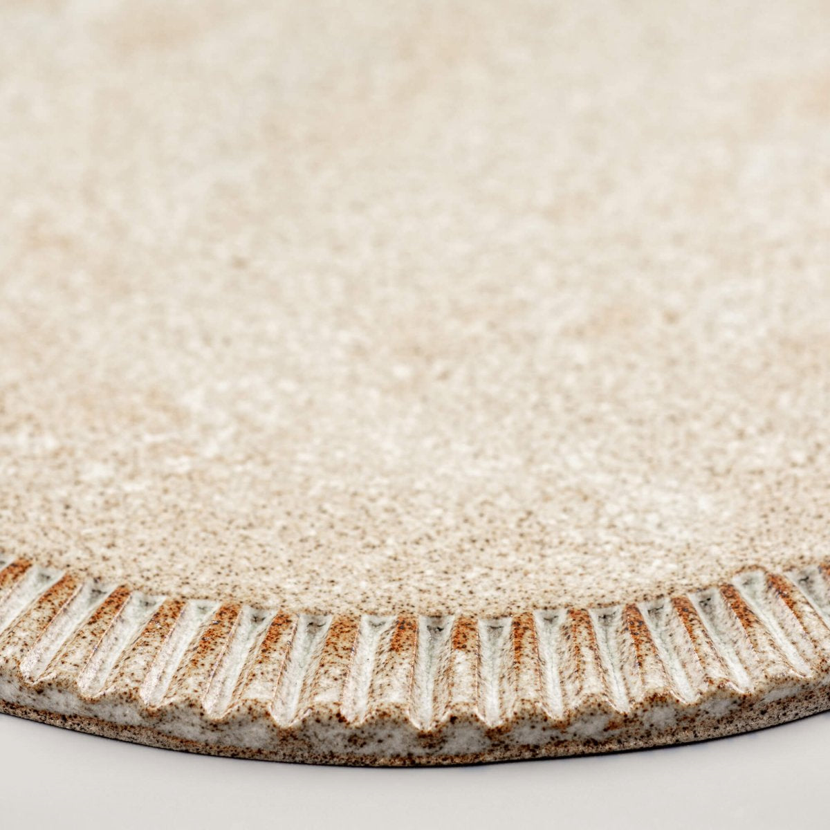 Rustic handmade ceramic plate with textured finish, suited for restaurant plating.