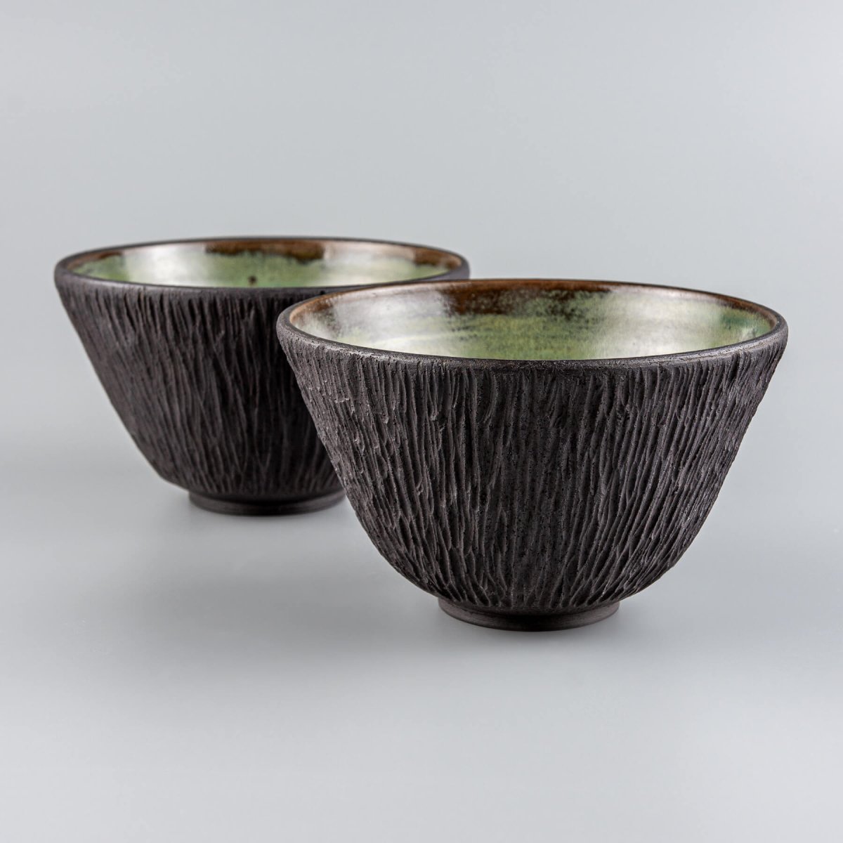 Top-down view of green glazed ceramic bowls for boutique restaurant table settings.