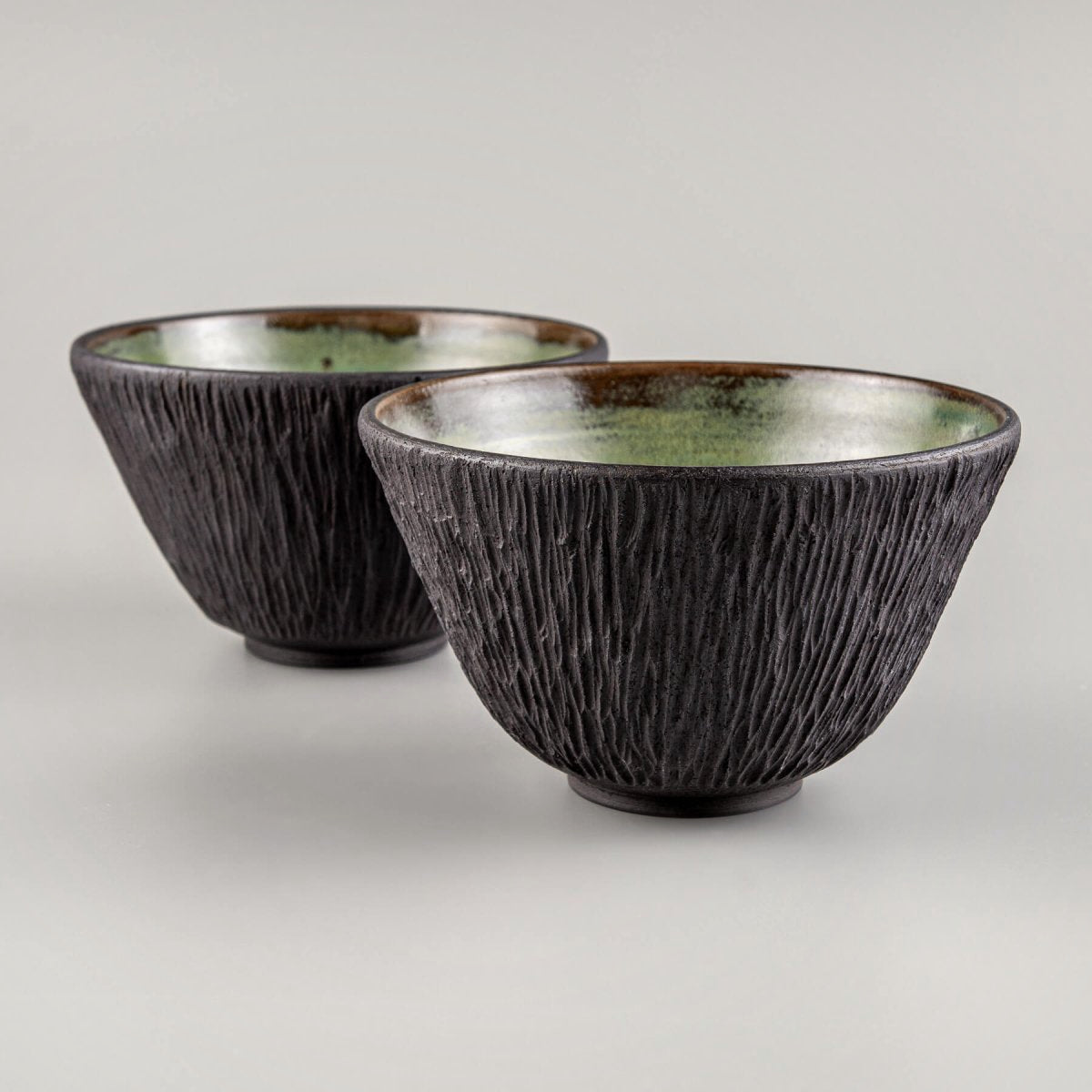 Top-down view of green glazed ceramic bowls for boutique restaurant table settings.