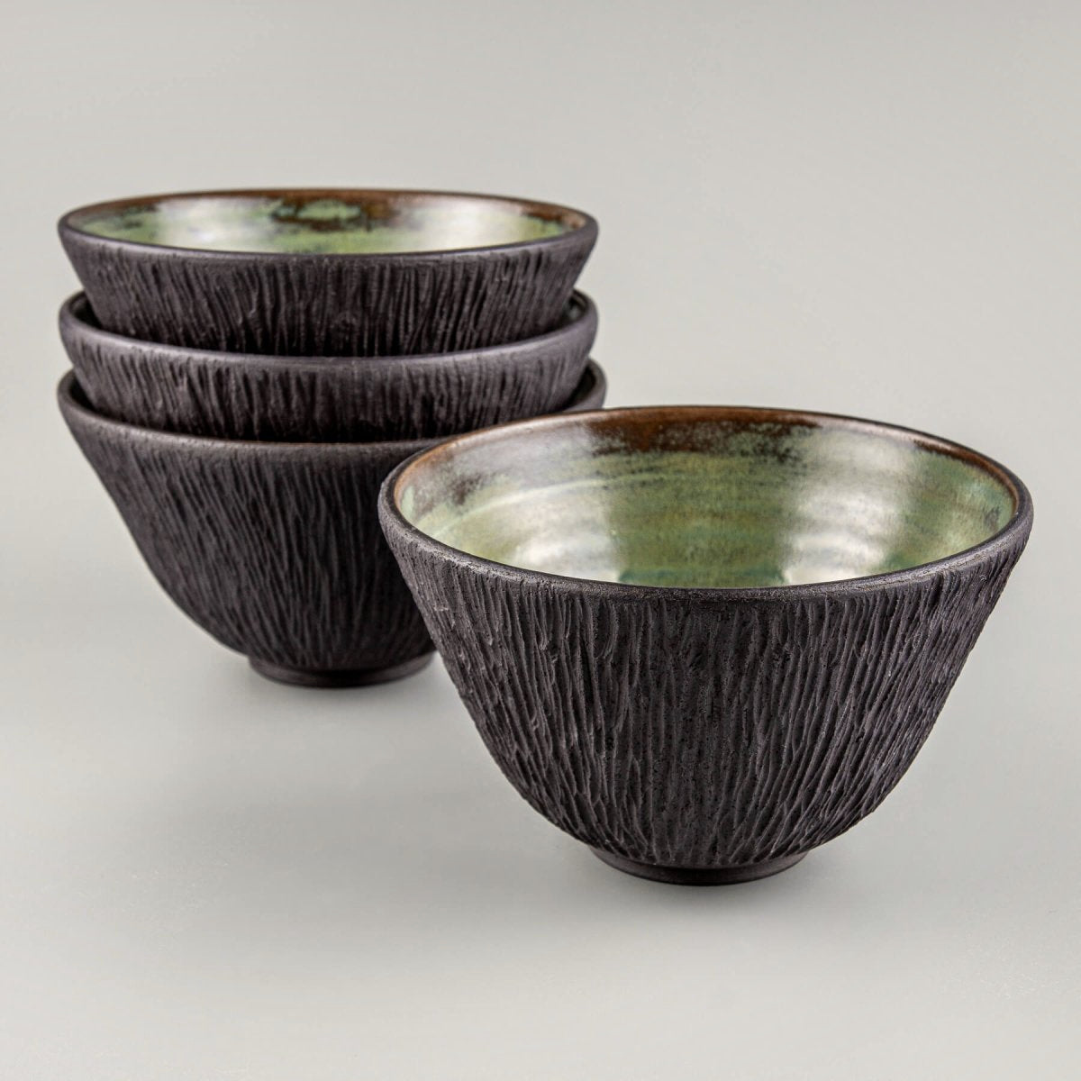 Fine dining ceramic tableware crafted from black stoneware clay with artistic detail.