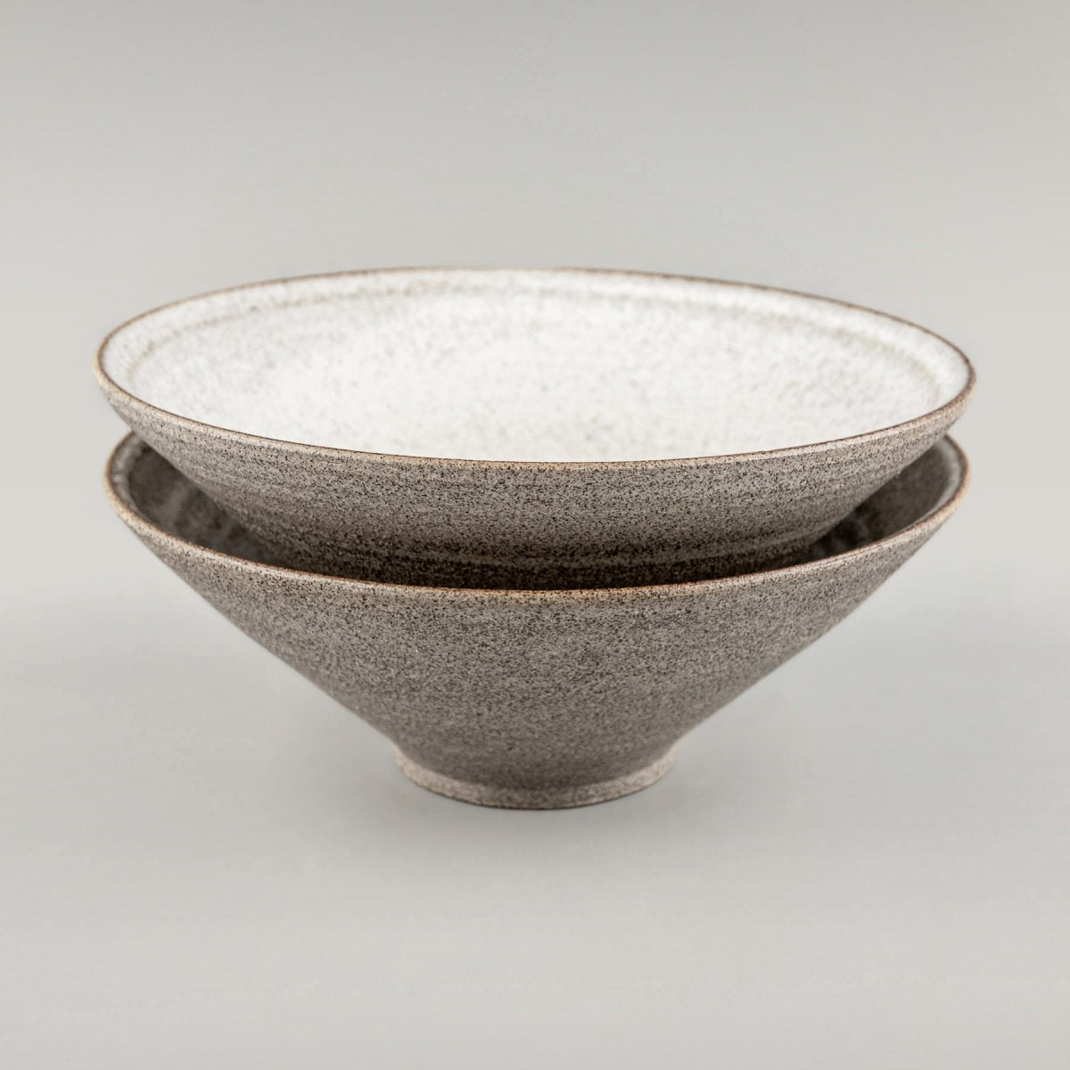 Profile view of handmade ceramic bowl with visible clay layers and artistic glaze finish.