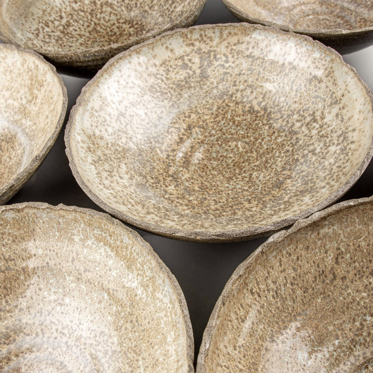 Arrangement of stoneware bowls showing handcrafted quality and organic ceramic aesthetics.