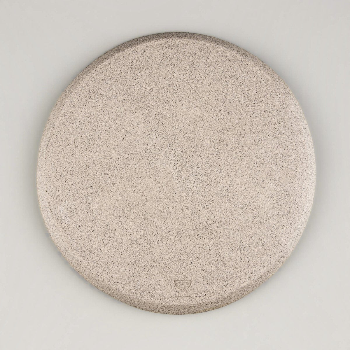Unglazed underside of handmade plate highlighting raw stoneware clay.