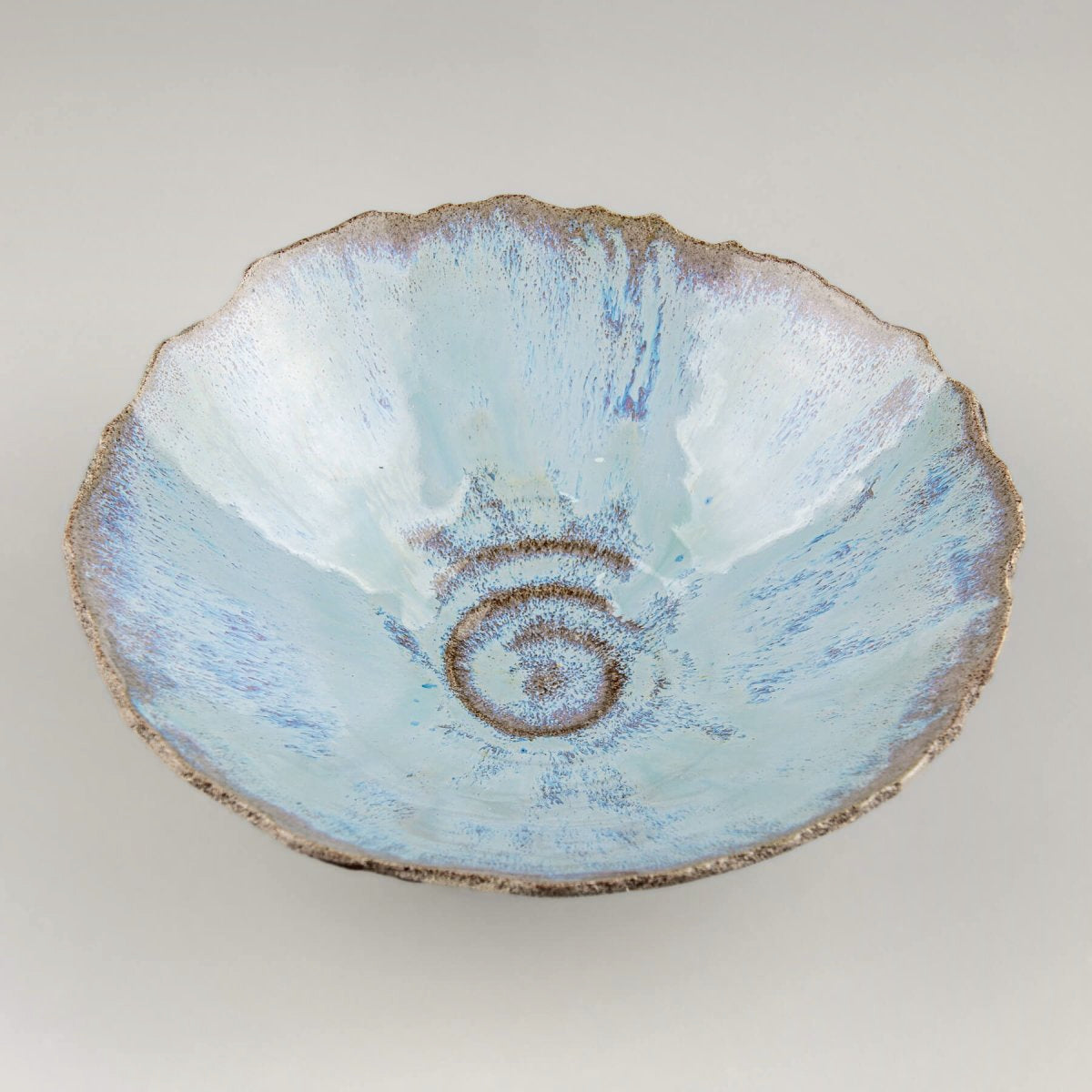 Side view of rustic ceramic bowl with textured unglazed exterior and stable base.