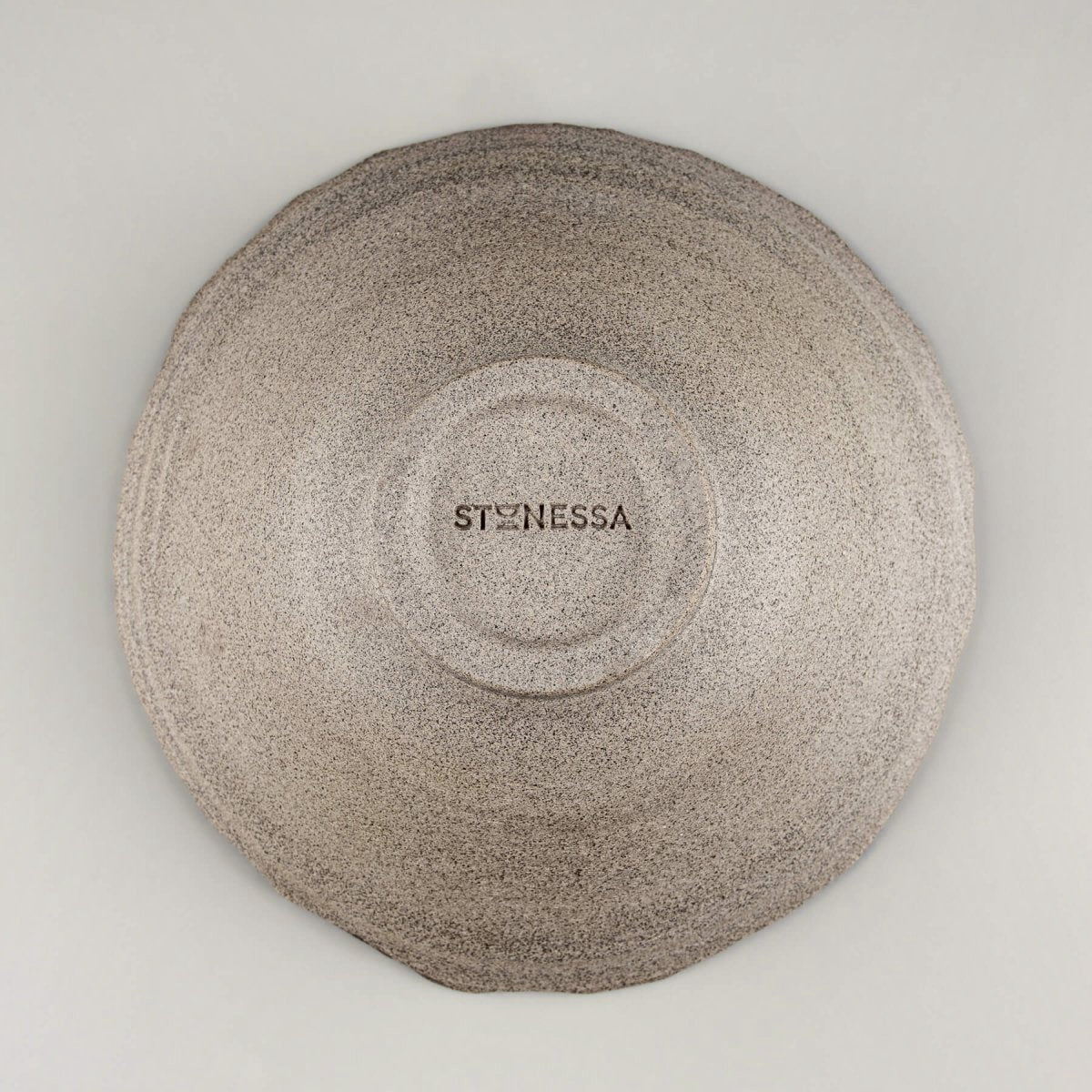 Underside view of handmade bowl showing unglazed surface and foot ring.