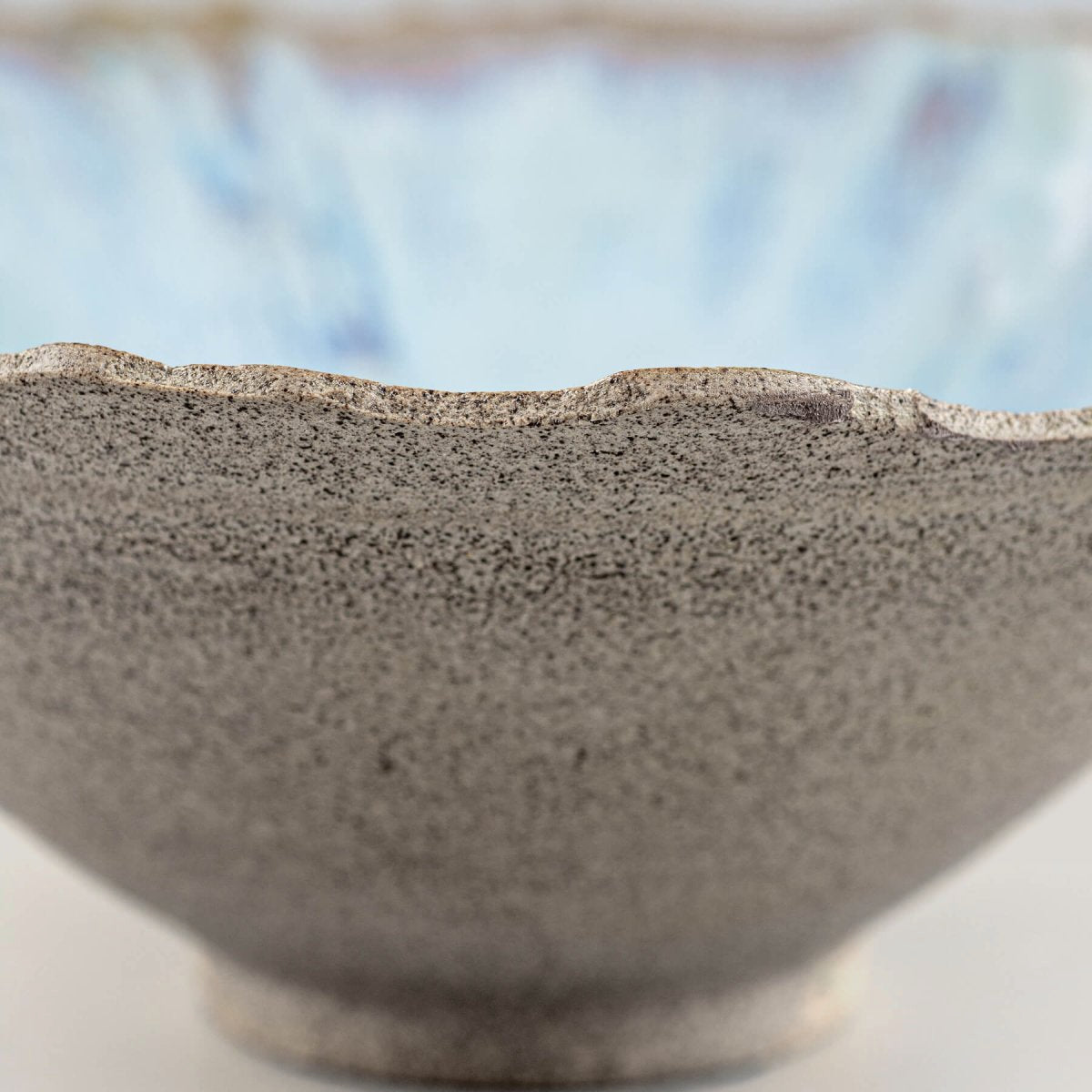 Close-up of handmade stoneware bowl’s interior showcasing blue glaze transitions.