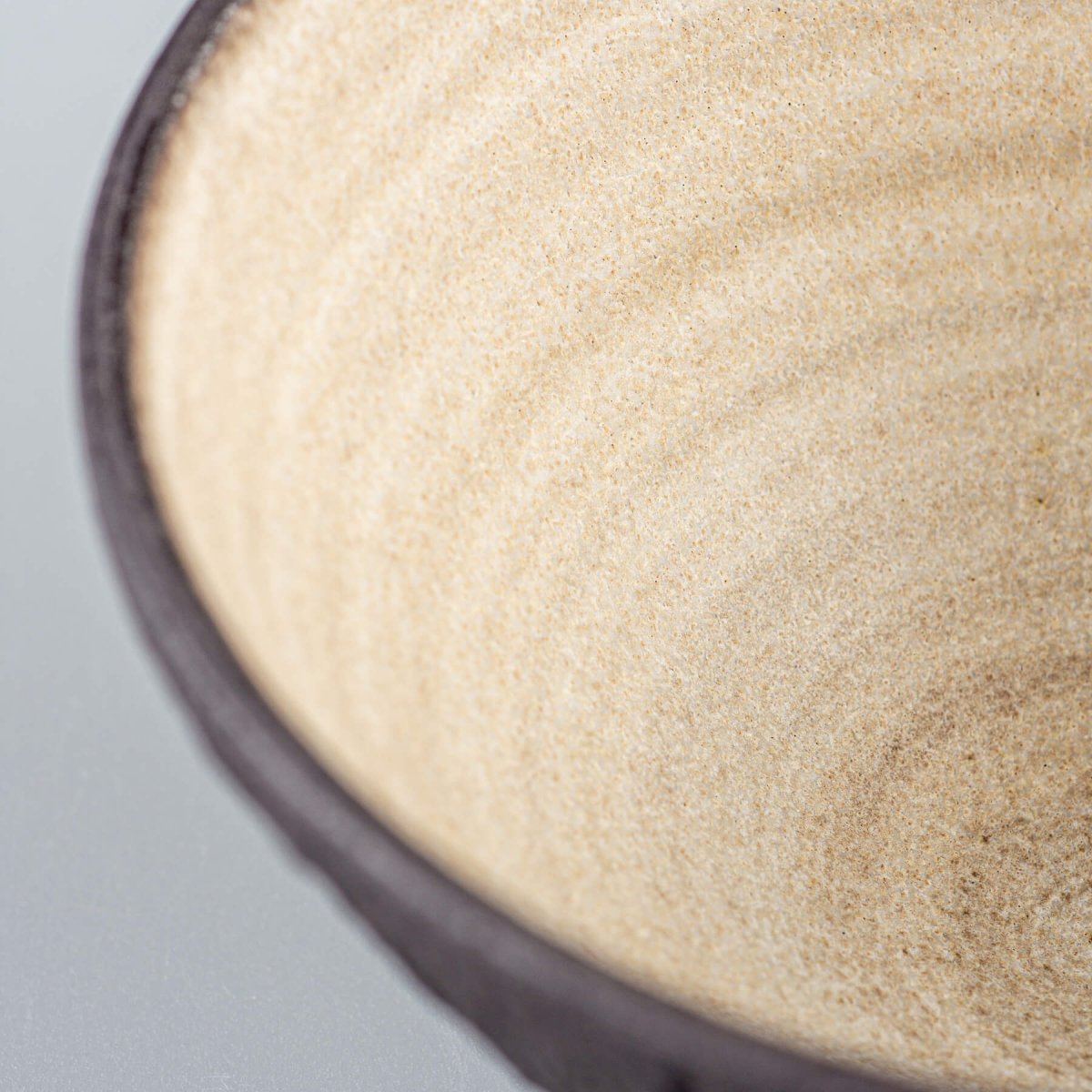 Close-up of interior matte beige glaze on artisan ceramic bowl, made for elegant food presentation.