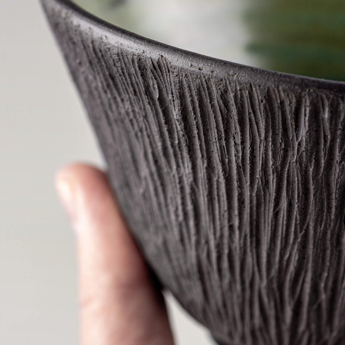 Textured dark stoneware surface of handmade ceramic bowl for home or boutique hotel use.