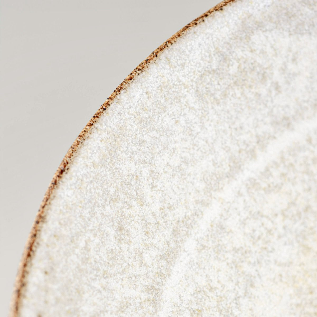 Close-up of rim detailing on handmade ceramic bowl with tactile stoneware texture.