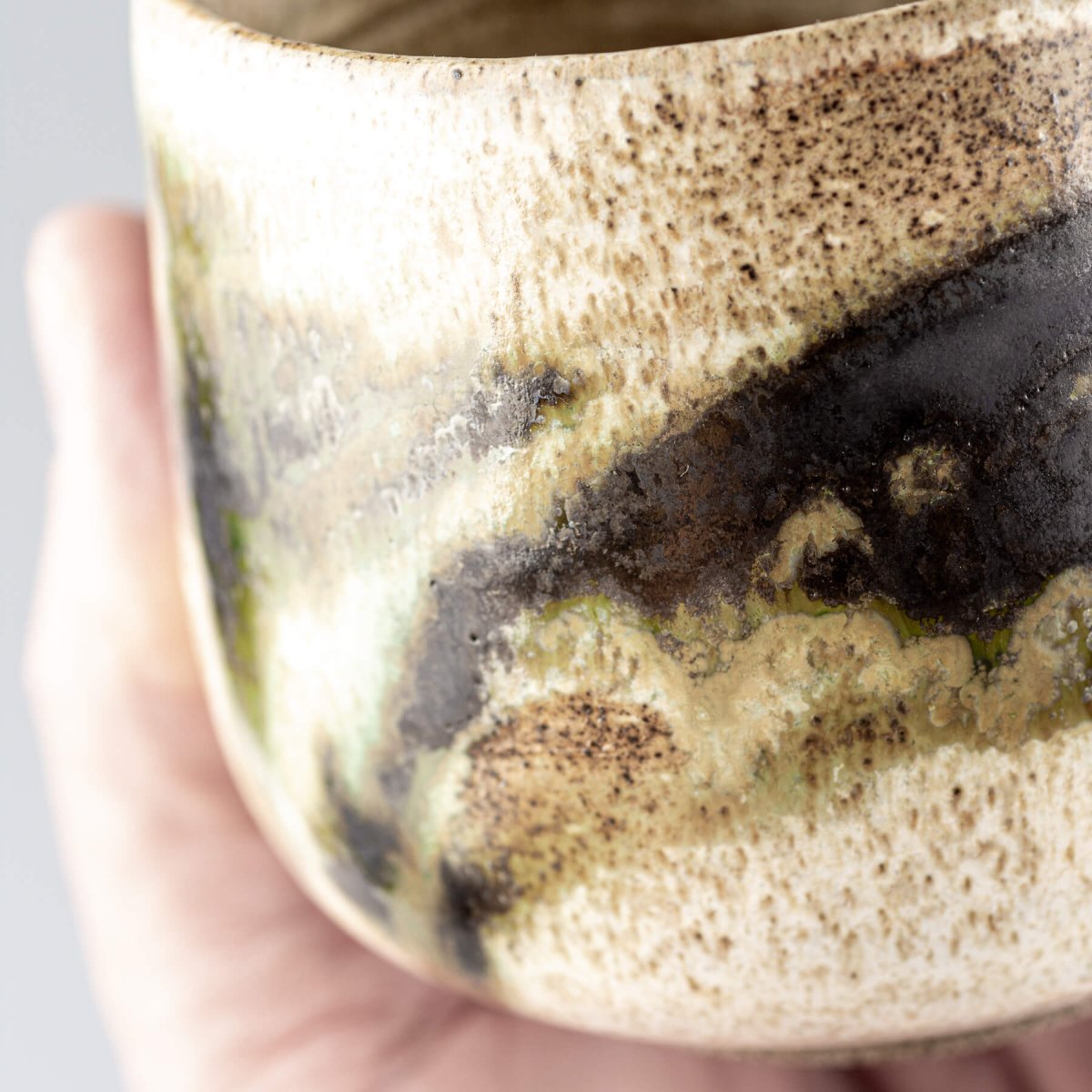 Unique ceramic stoneware mug with layered glaze artistry for collectible tableware.