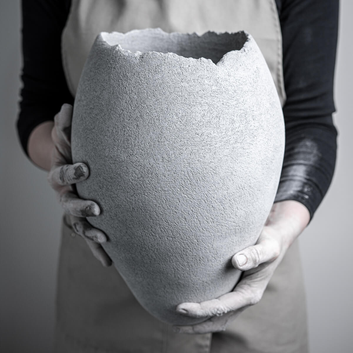 Large handmade vases in sculptural stoneware clay held by the artist with a raw textured surface.