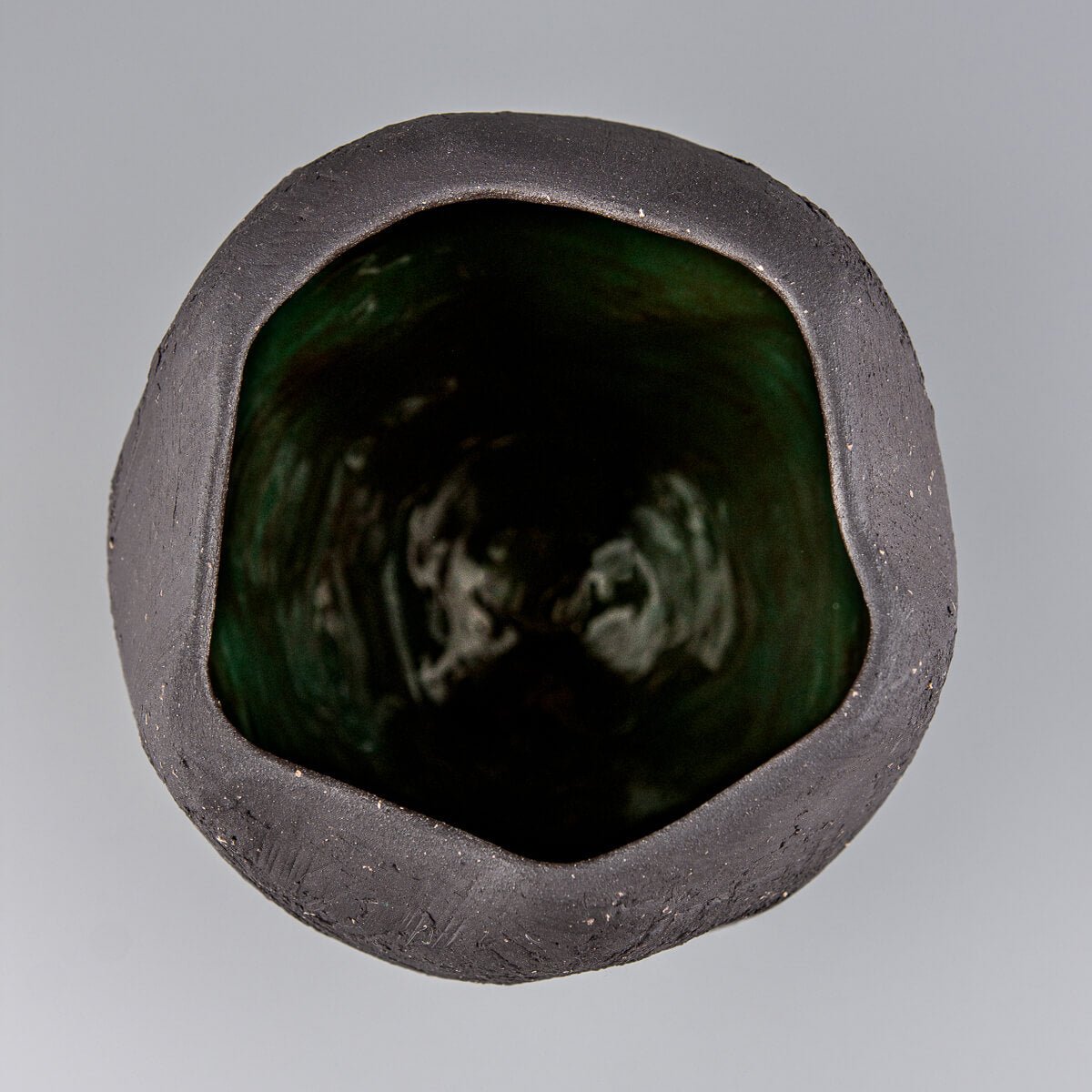 Collectible pottery vase with rustic unglazed exterior and glossy green inside.