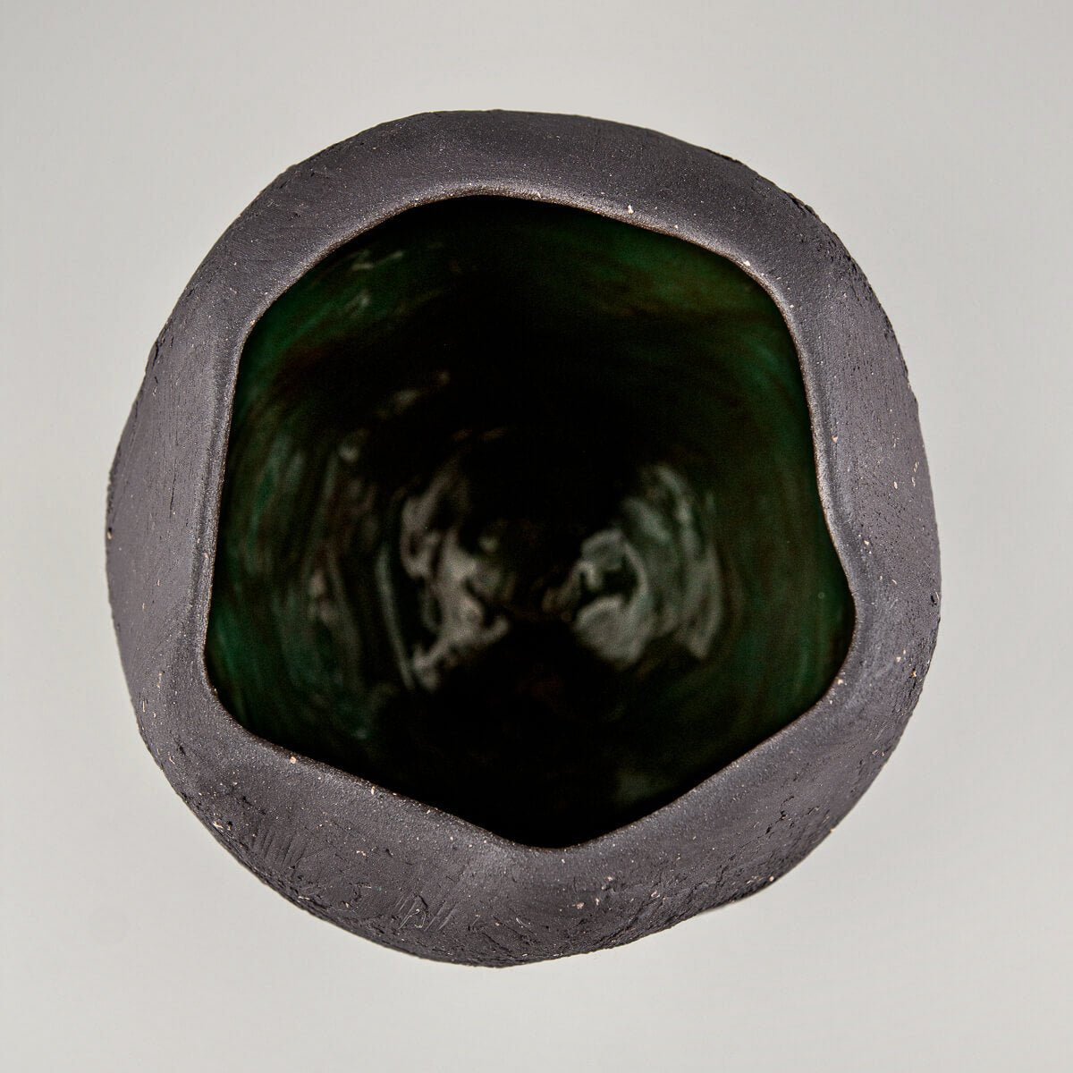 Collectible pottery vase with rustic unglazed exterior and glossy green inside.