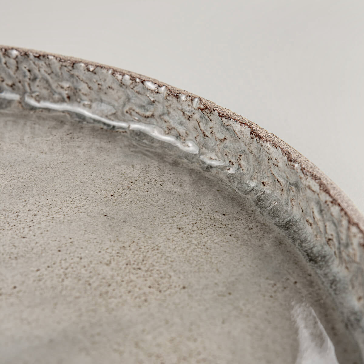 Detail of premium stoneware edge with artisanal carving and refined glaze finish.
