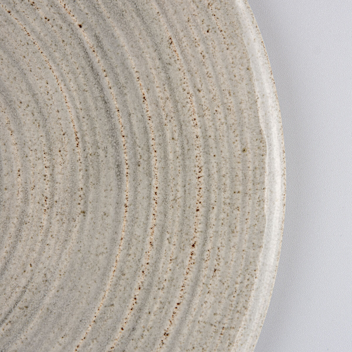 Side view of handmade flat ceramic tableware for elegant food styling.