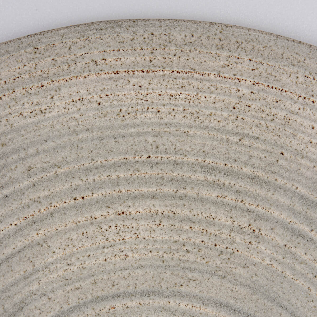 Natural clay edge detail on handcrafted plate for collectible kitchenware.