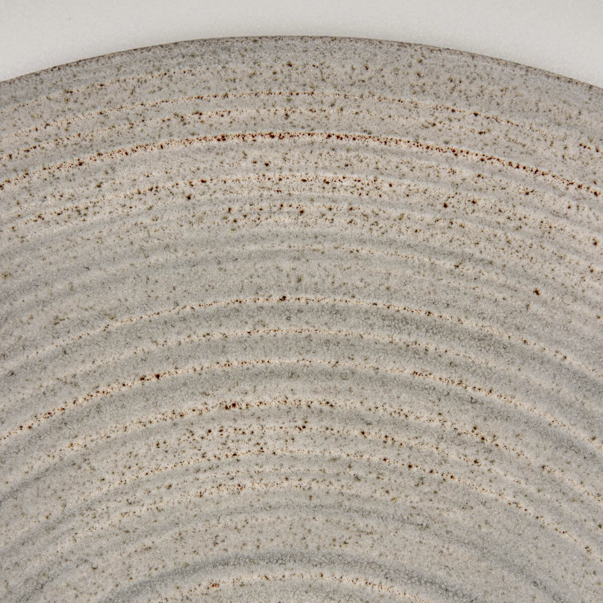 Natural clay edge detail on handcrafted plate for collectible kitchenware.