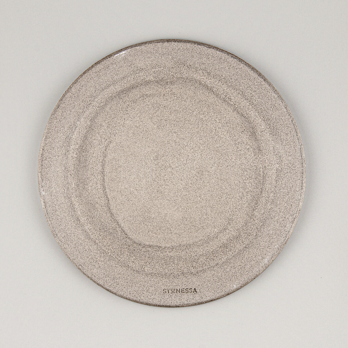 Top view of modern ceramic plate with circular throwing marks and matte finish.
