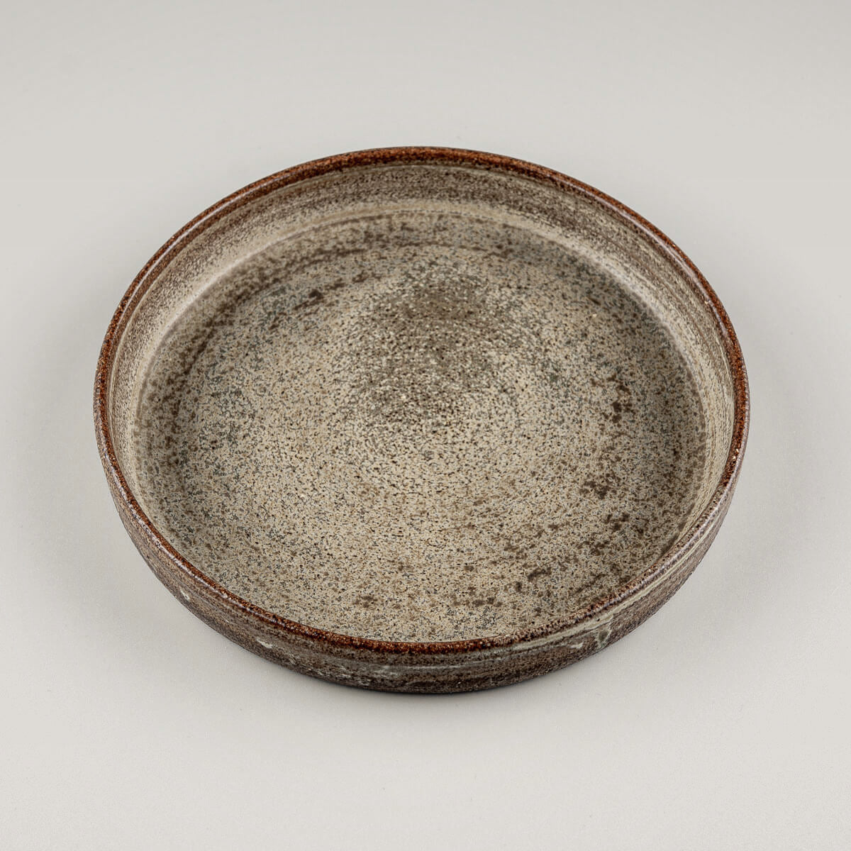 Top view of artisanal ceramic plate for home kitchens, collectible pottery lovers, or hotel tableware.