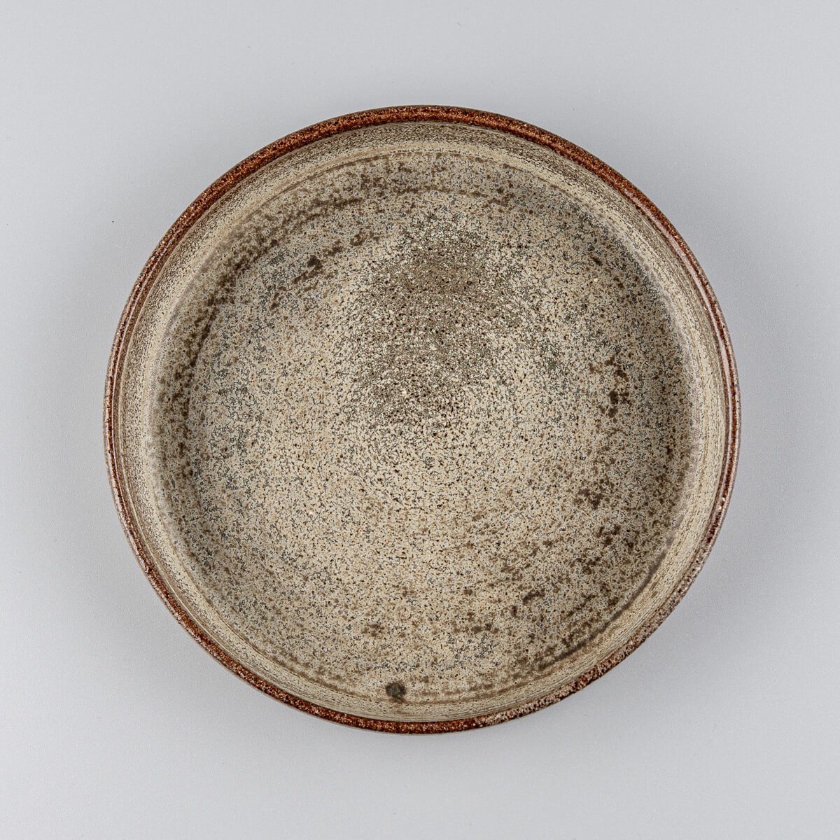Handmade stoneware plate with rustic beige glaze, ideal for fine dining or boutique restaurant use.