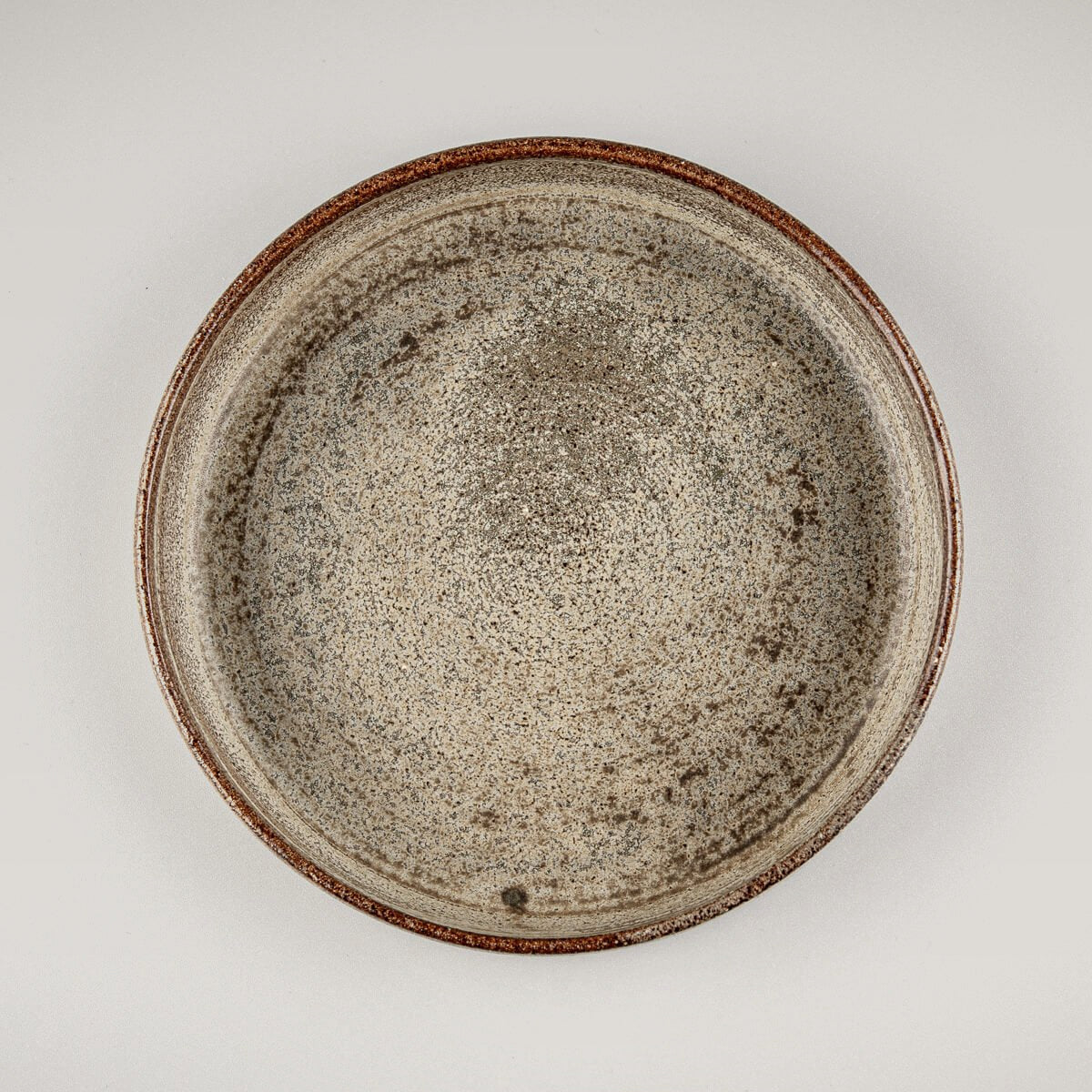 Handmade stoneware plate with rustic beige glaze, ideal for fine dining or boutique restaurant use.