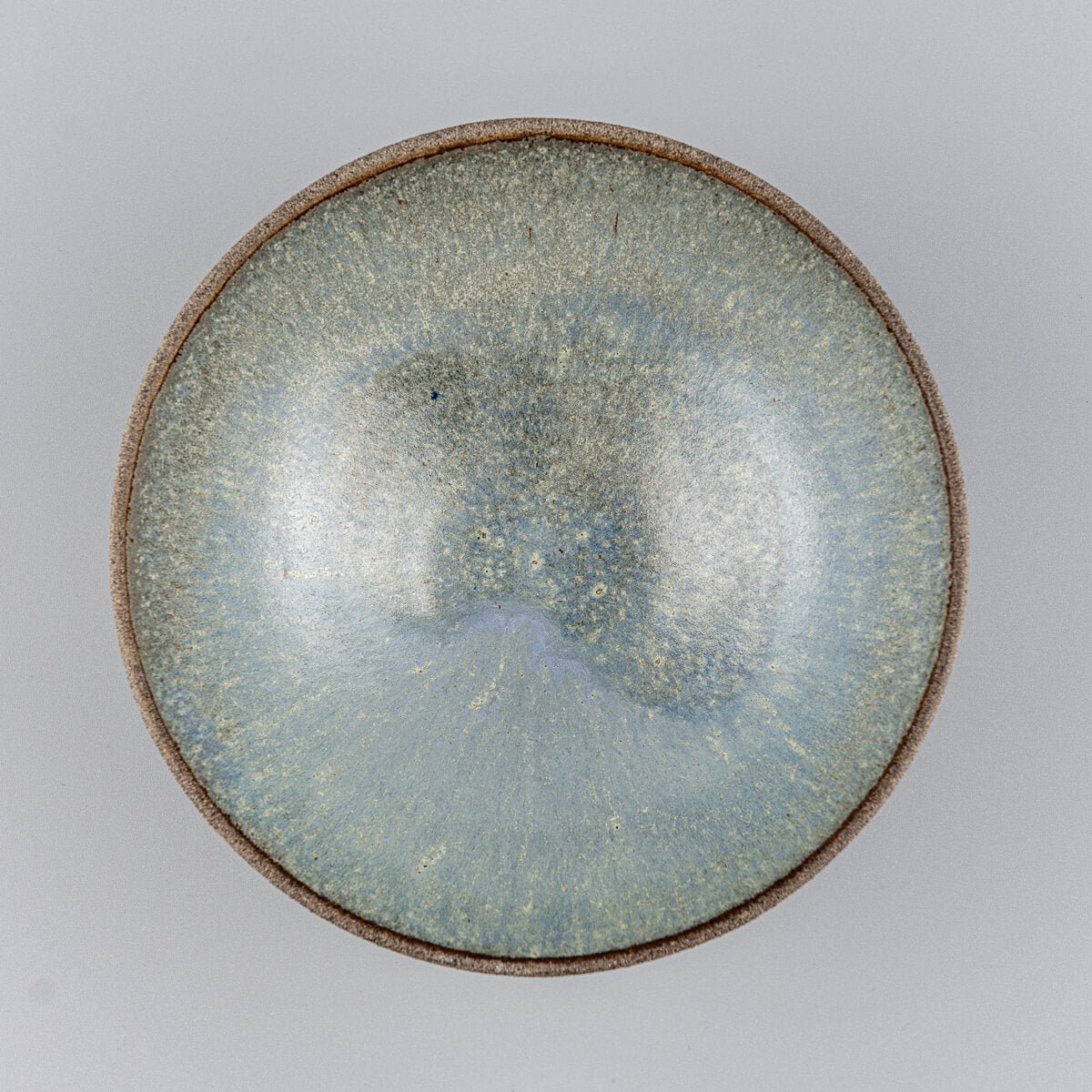 Top-down view of ceramic bowl showing smooth blue glazed interior surface.