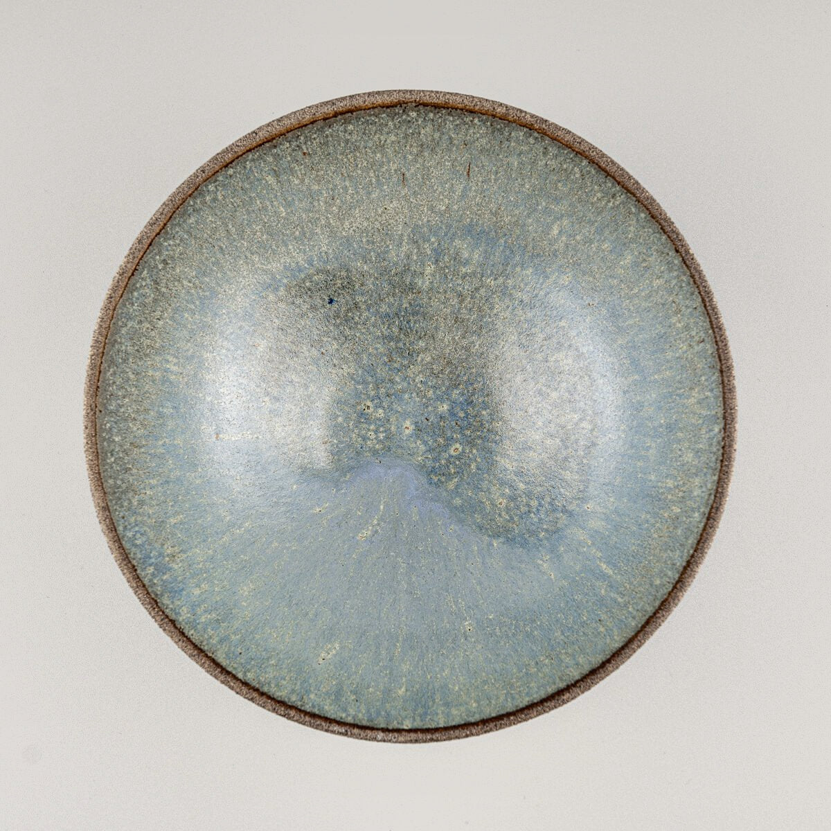 Top-down view of ceramic bowl showing smooth blue glazed interior surface.