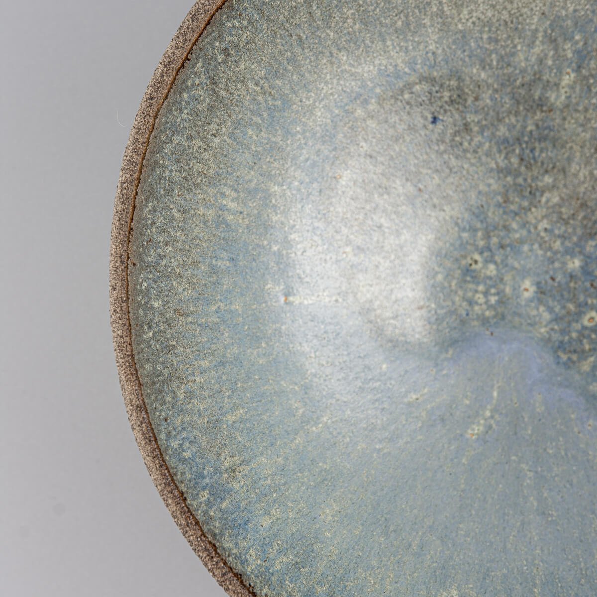 Detail of rim and inner surface showcasing artisan glaze of ceramic serving bowl.