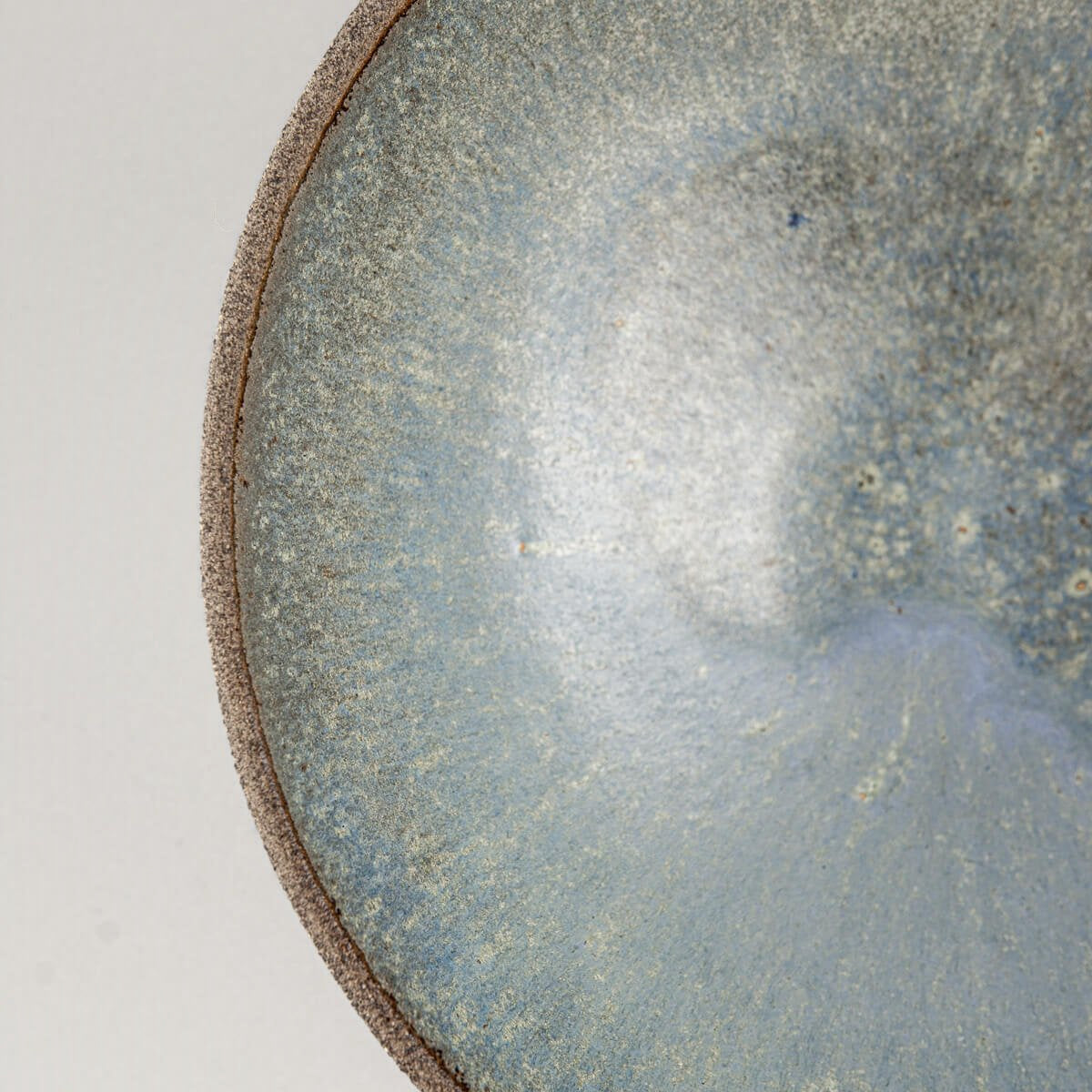 Detail of rim and inner surface showcasing artisan glaze of ceramic serving bowl.