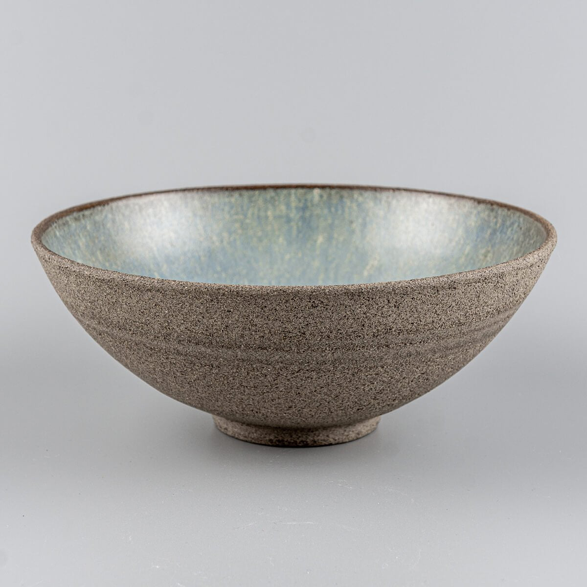 Frontal angled view of handcrafted stoneware bowl with wide profile and minimalist form.