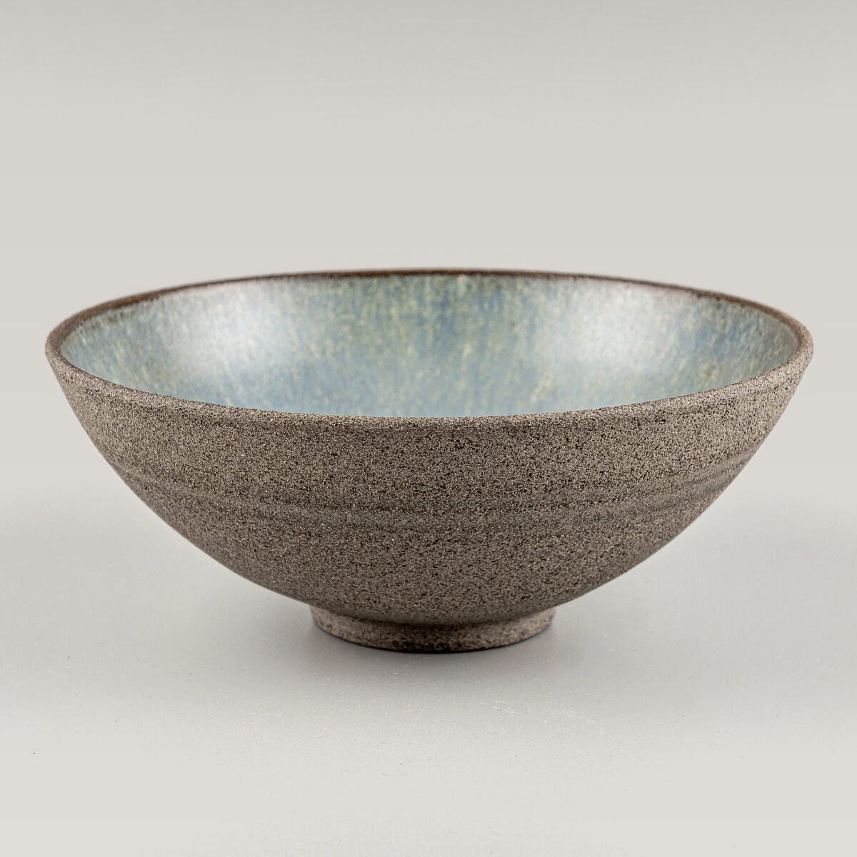 Frontal angled view of handcrafted stoneware bowl with wide profile and minimalist form.