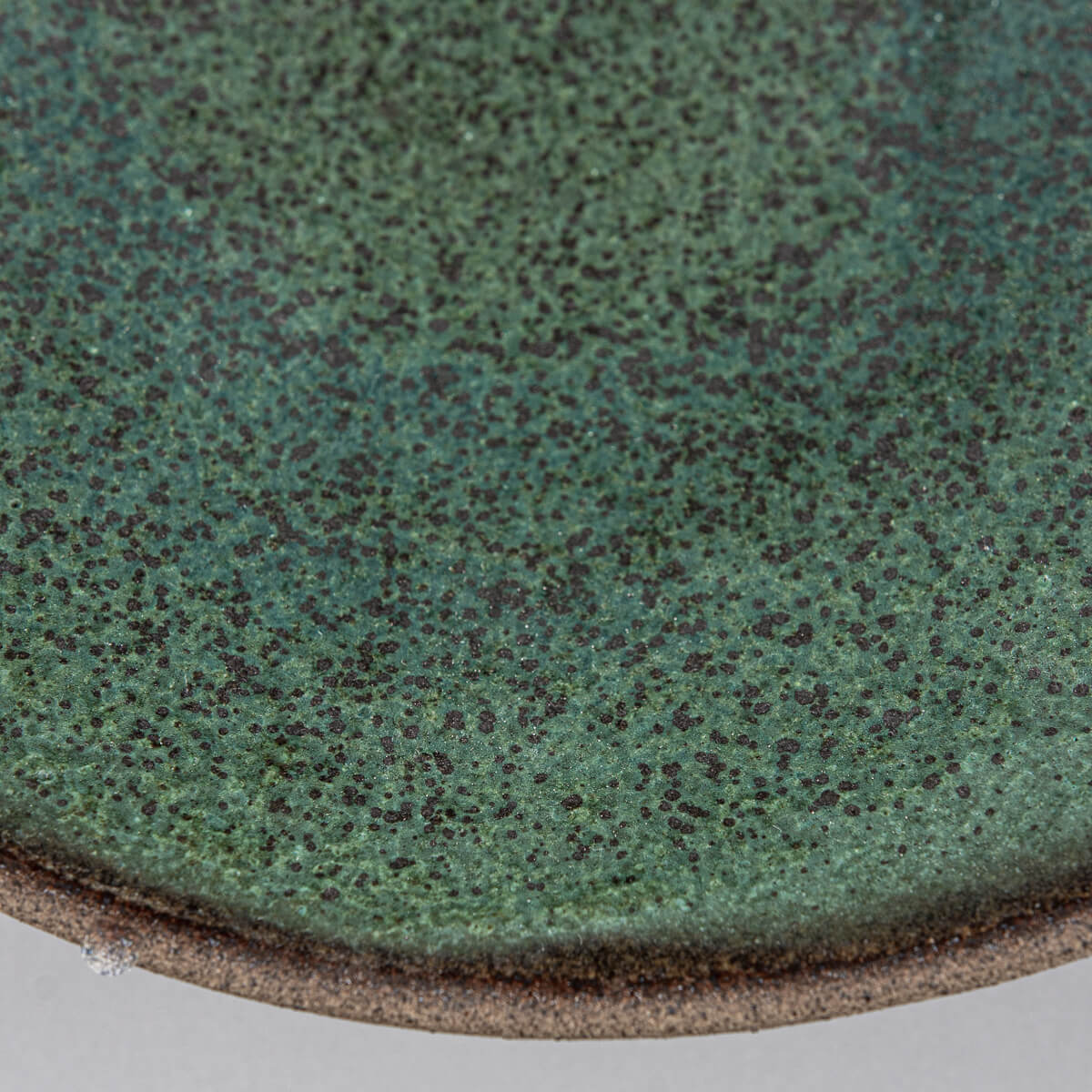 Speckled ceramic surface showing unique handcrafted glaze for stylish culinary use.