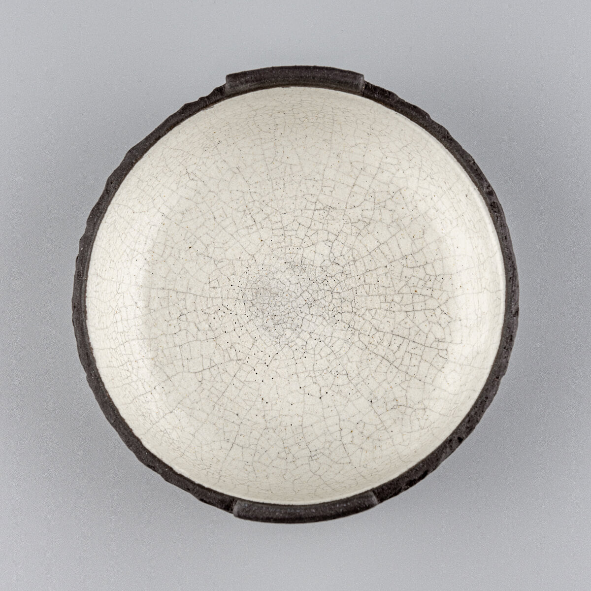 Top-down view of handcrafted ceramic bowl showing textured white interior and round profile.