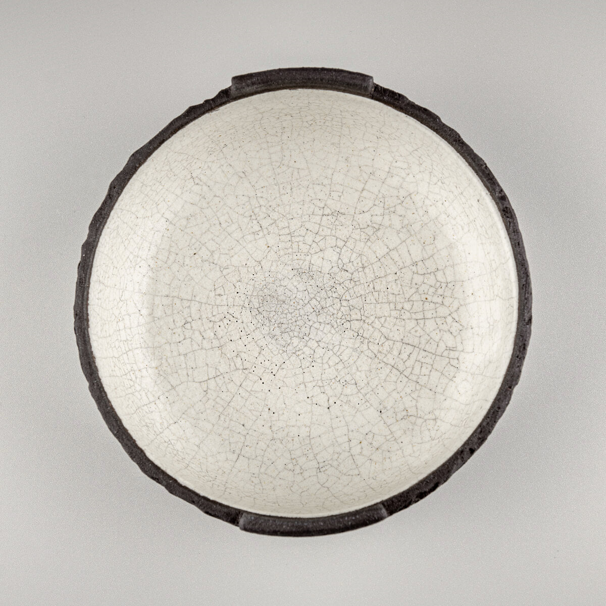 Top-down view of handcrafted ceramic bowl showing textured white interior and round profile.