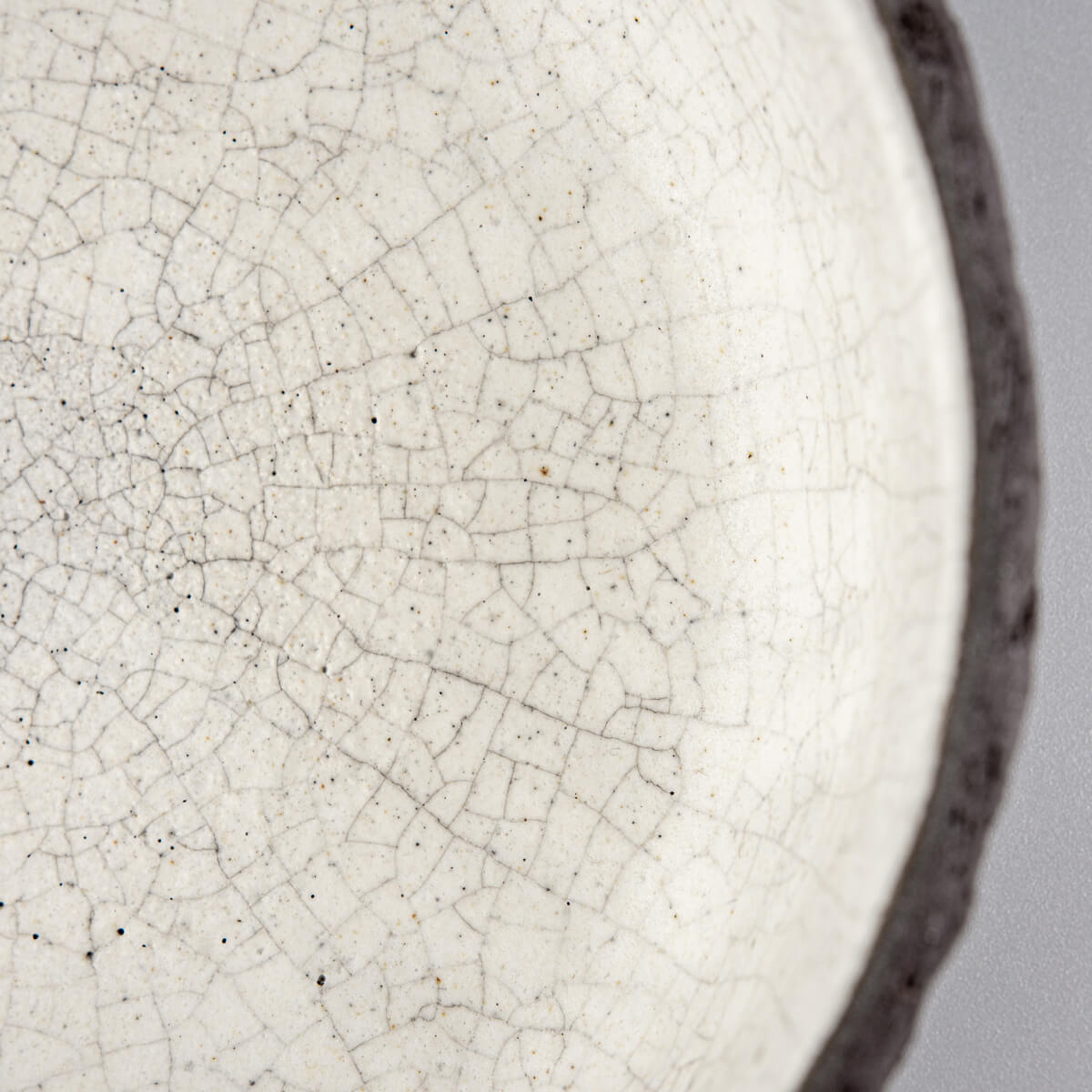 Close-up of crackled white glaze inside handmade ceramic bowl for home and fine dining.