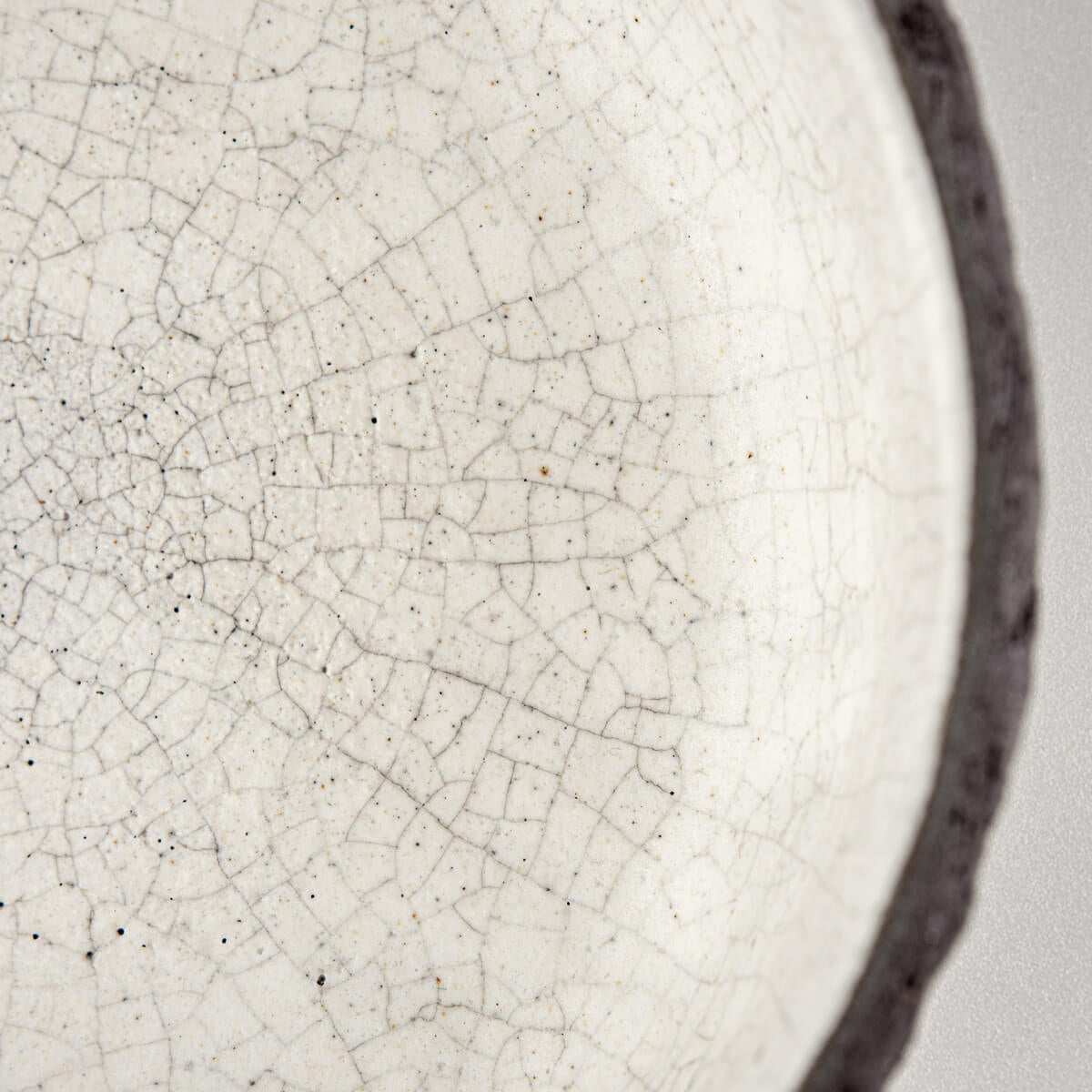 Close-up of crackled white glaze inside handmade ceramic bowl for home and fine dining.