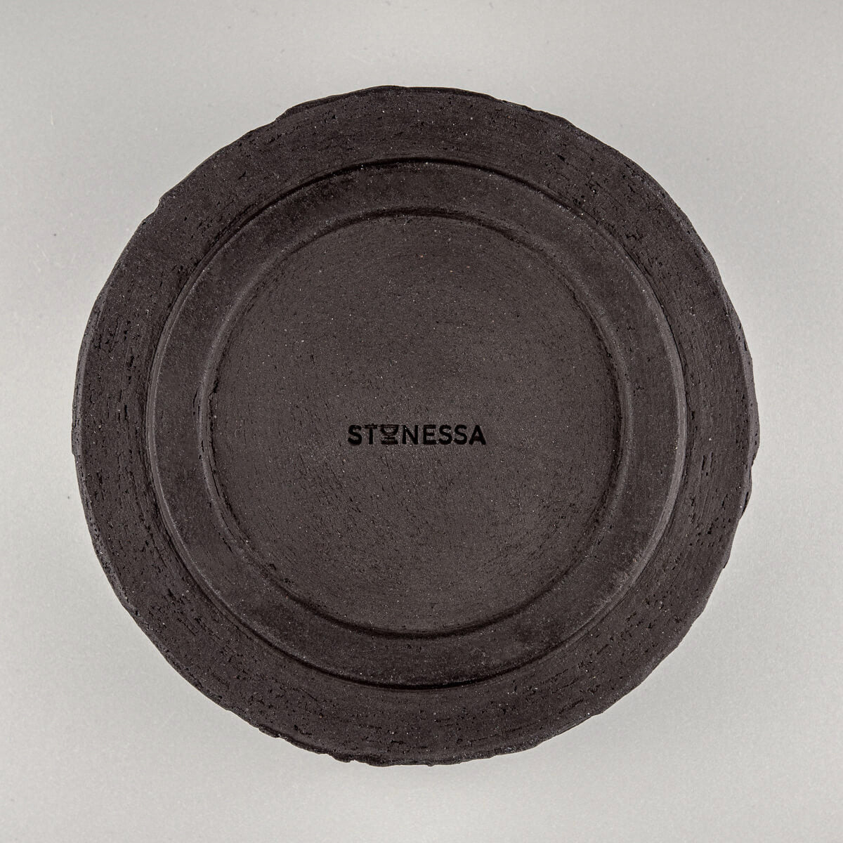 Bottom view of pottery bowl showing artist’s signature and raw ceramic base.