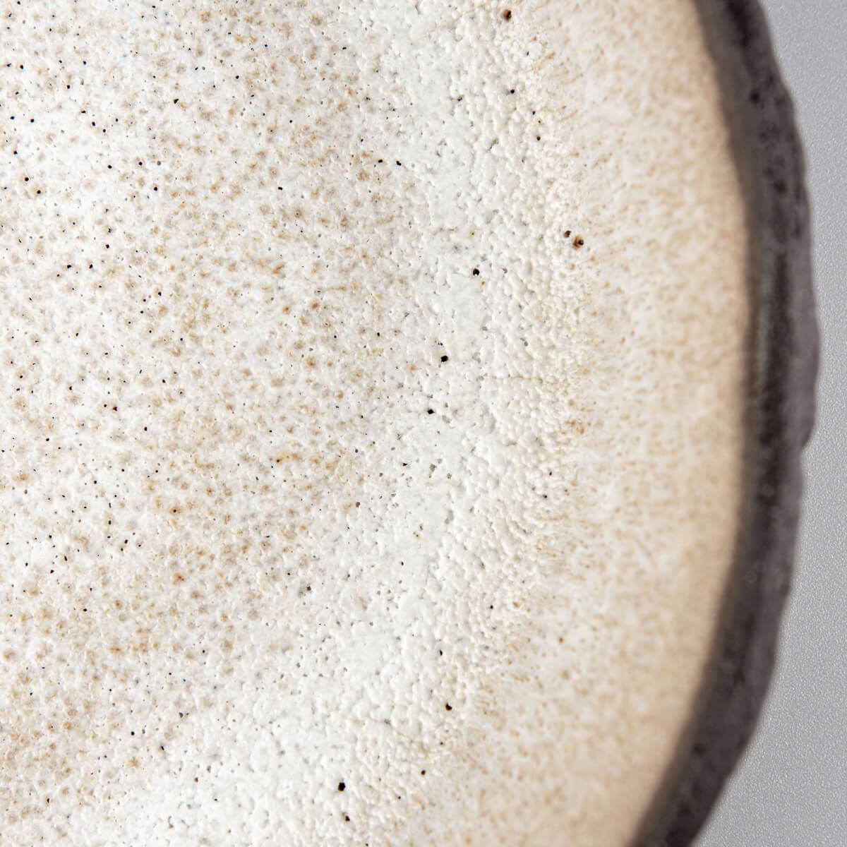 Detail of matte white glaze inside ceramic plate designed for boutique restaurants and modern kitchens.
