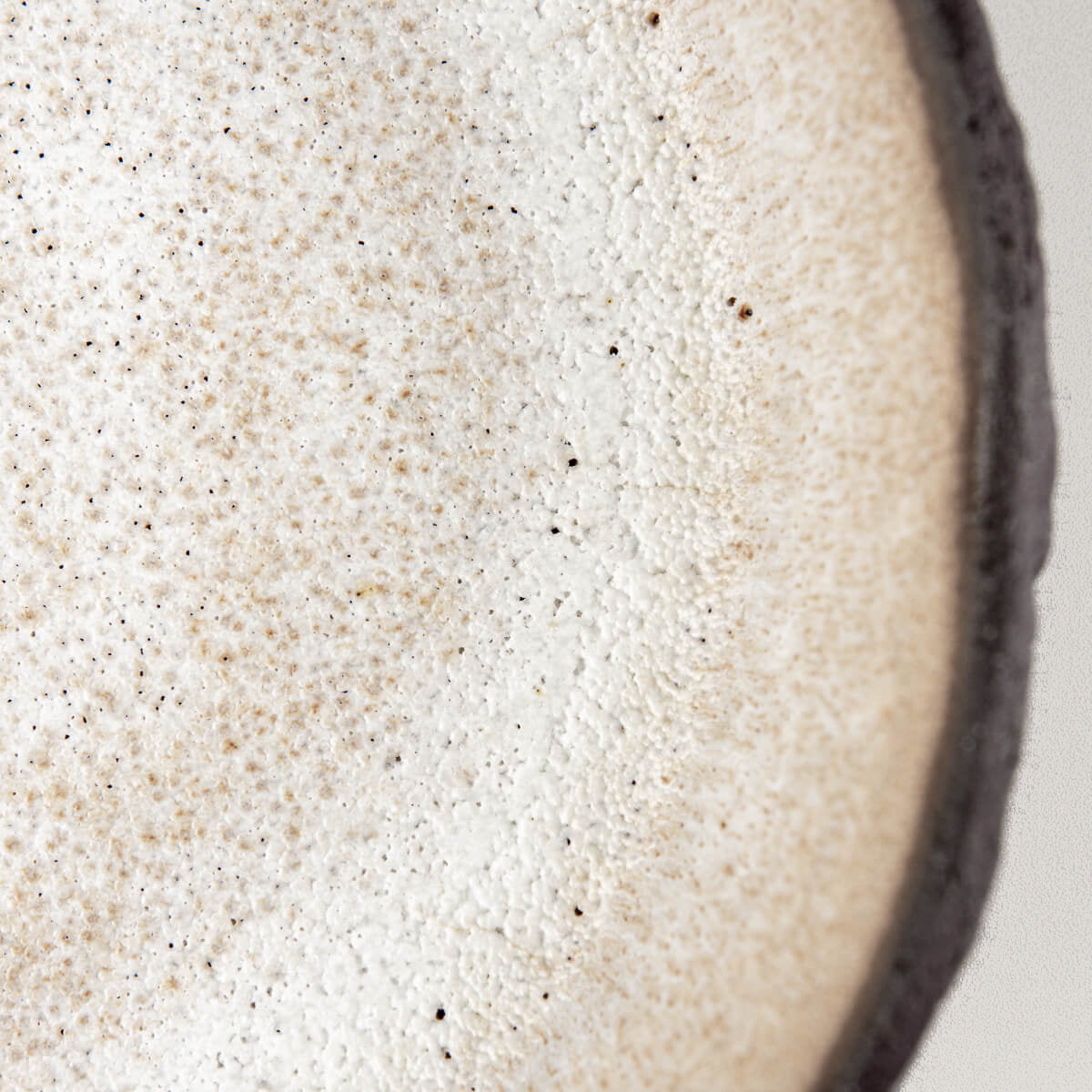 Detail of matte white glaze inside ceramic plate designed for boutique restaurants and modern kitchens.