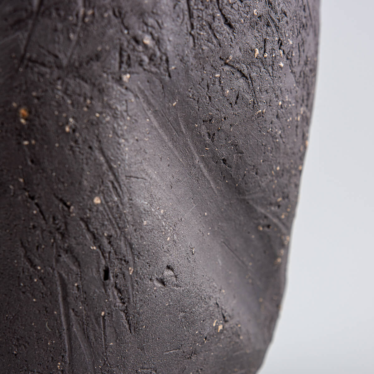 Artisan pottery vase with natural black stoneware finish and green interior.