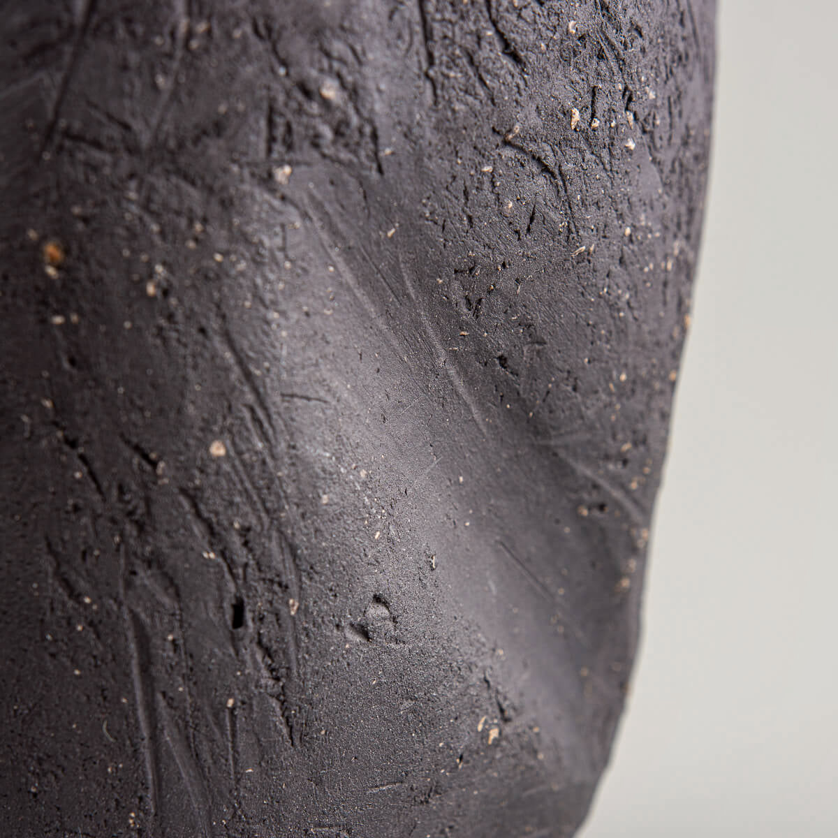 Artisan pottery vase with natural black stoneware finish and green interior.