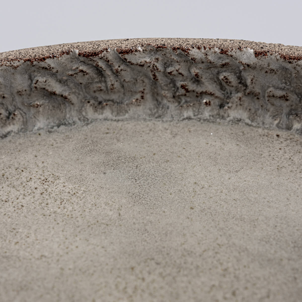 Zoomed texture of inner rim showing craftsmanship in hand-carved ceramic plate.