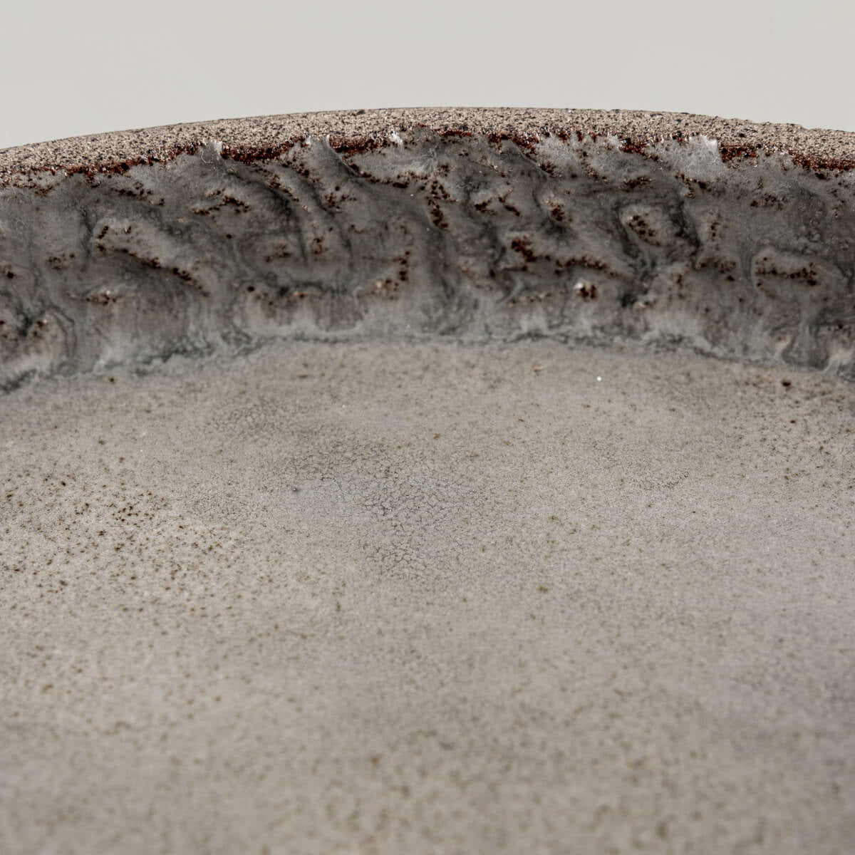 Zoomed texture of inner rim showing craftsmanship in hand-carved ceramic plate.
