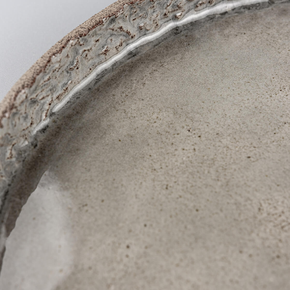 Natural stoneware texture under glossy finish on a refined ceramic dinner plate.
